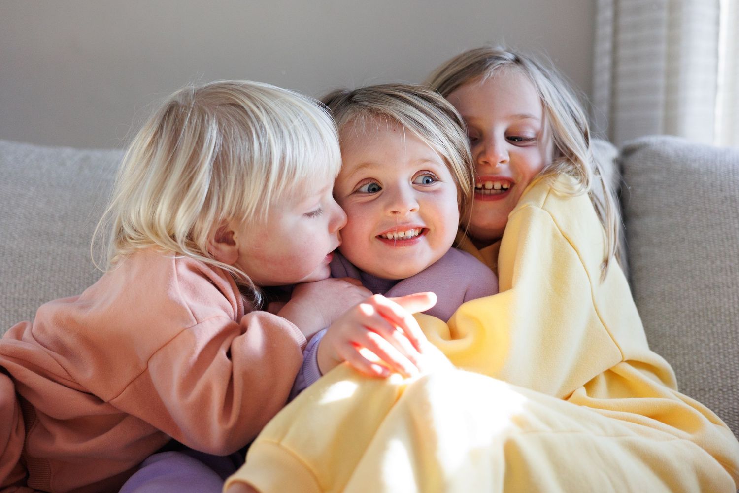 photo showing children sharing sweet moments and interactions together. colorful sweatsuits