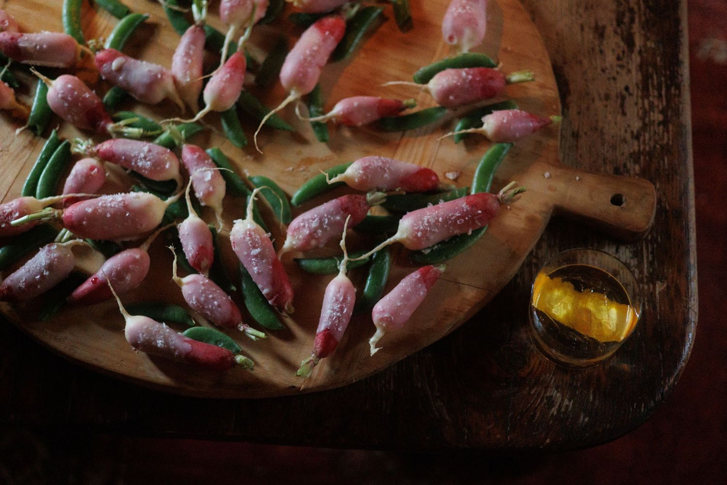 Fresh radish with butter arranged with herbs and seasonings on a rustic wooden surface. north shore massachusetts