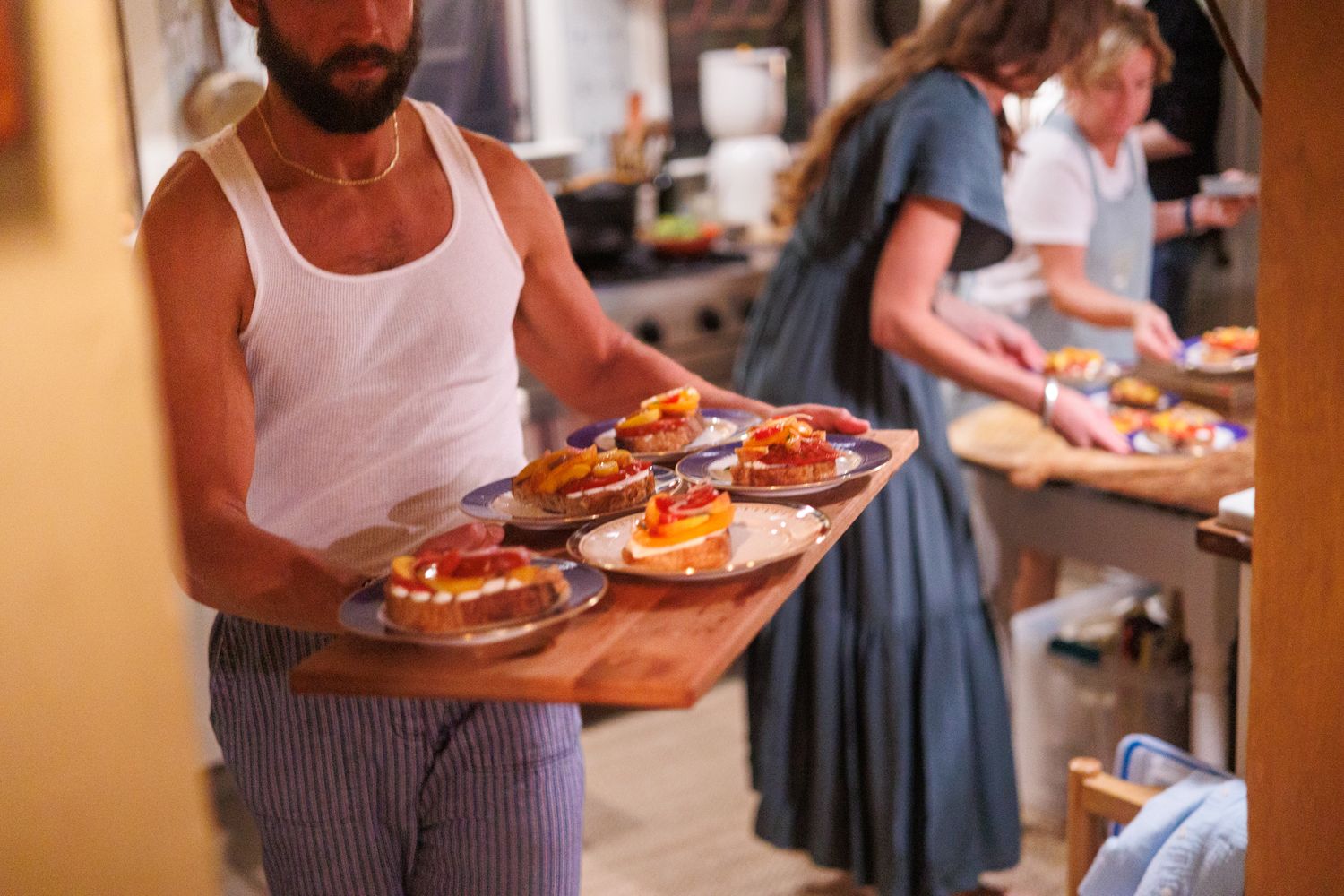 Person holding tray, serving plates of food, kitchen atmosphere, busy hands preparing food, north shore massachusetts