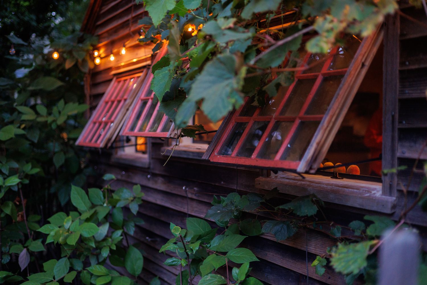 Rustic wooden cabin porch decorated with glowing string lights at dusk creates a cozy ambiance. north shore massachusetts