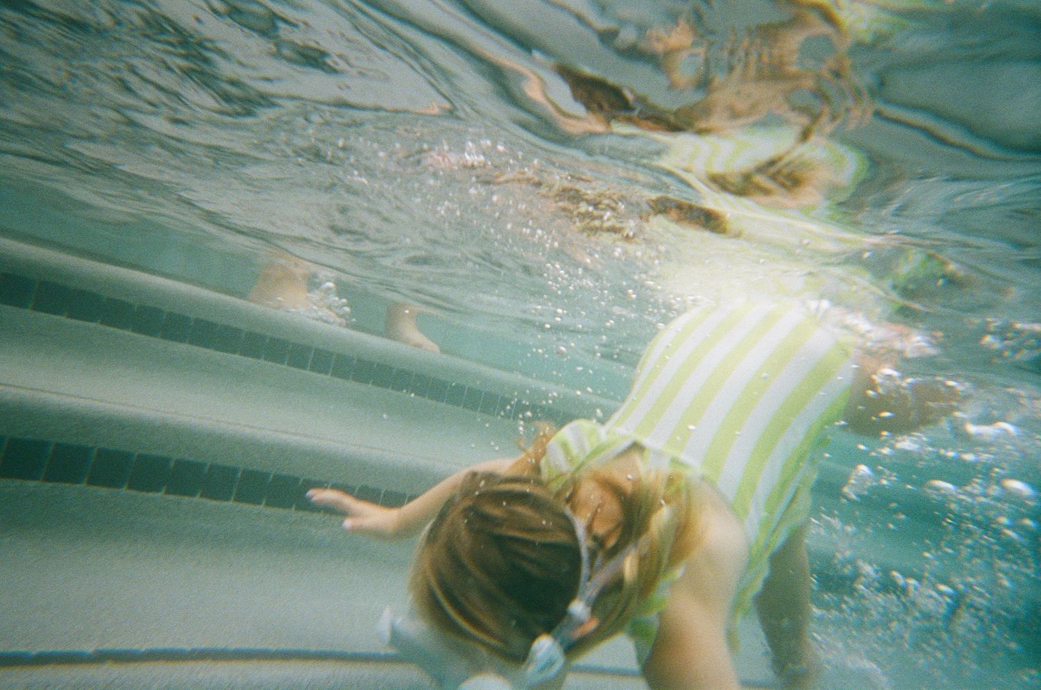 girl diving in water, pool, striped swimsuit, goggles, underwater camera, north shore massachusetts