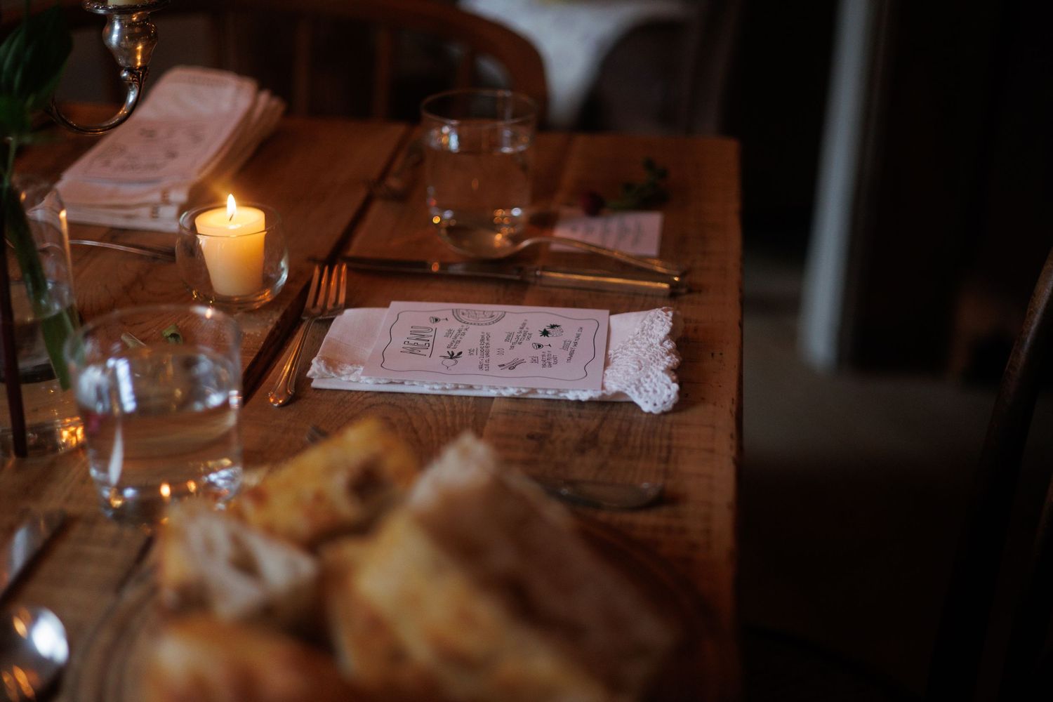 A candlelit dinner table with wine glasses and plates of food in a cozy restaurant setting. north shore massachusetts