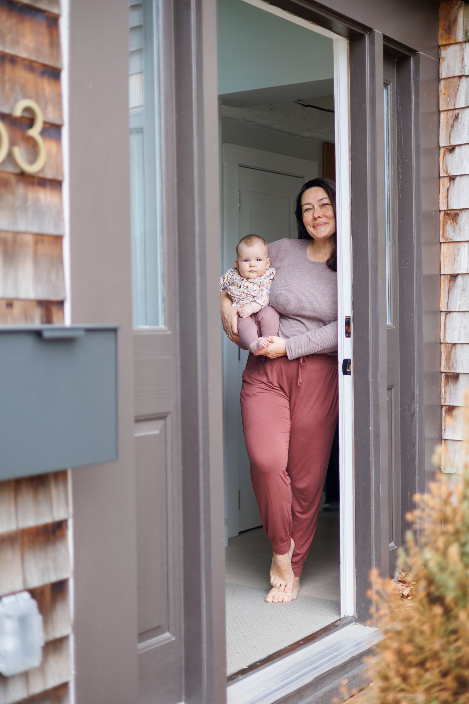 mom and baby, colorful outfits, welcoming in doorway, in home photos, north shore massachusetts