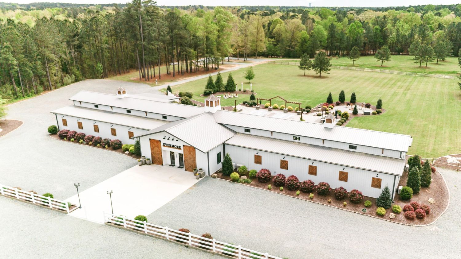 Aerial view of a sprawling rural property with green fields and buildings at the Evermore with Cary NC Wedding Photographer