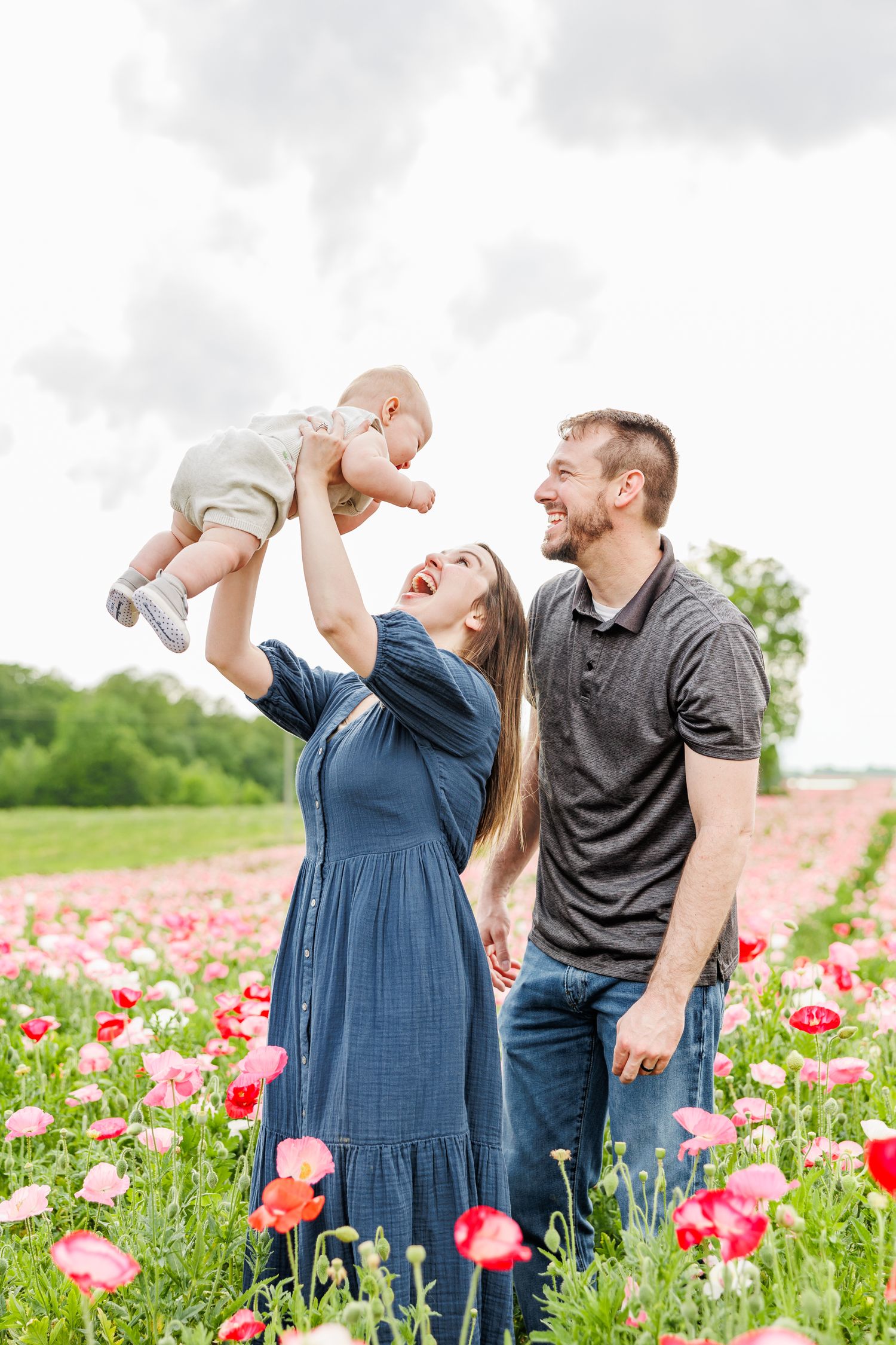 Family plays together in a vibrant field of pink and red poppies on a spring day  in Winston Salem NC  with a Family Photographer