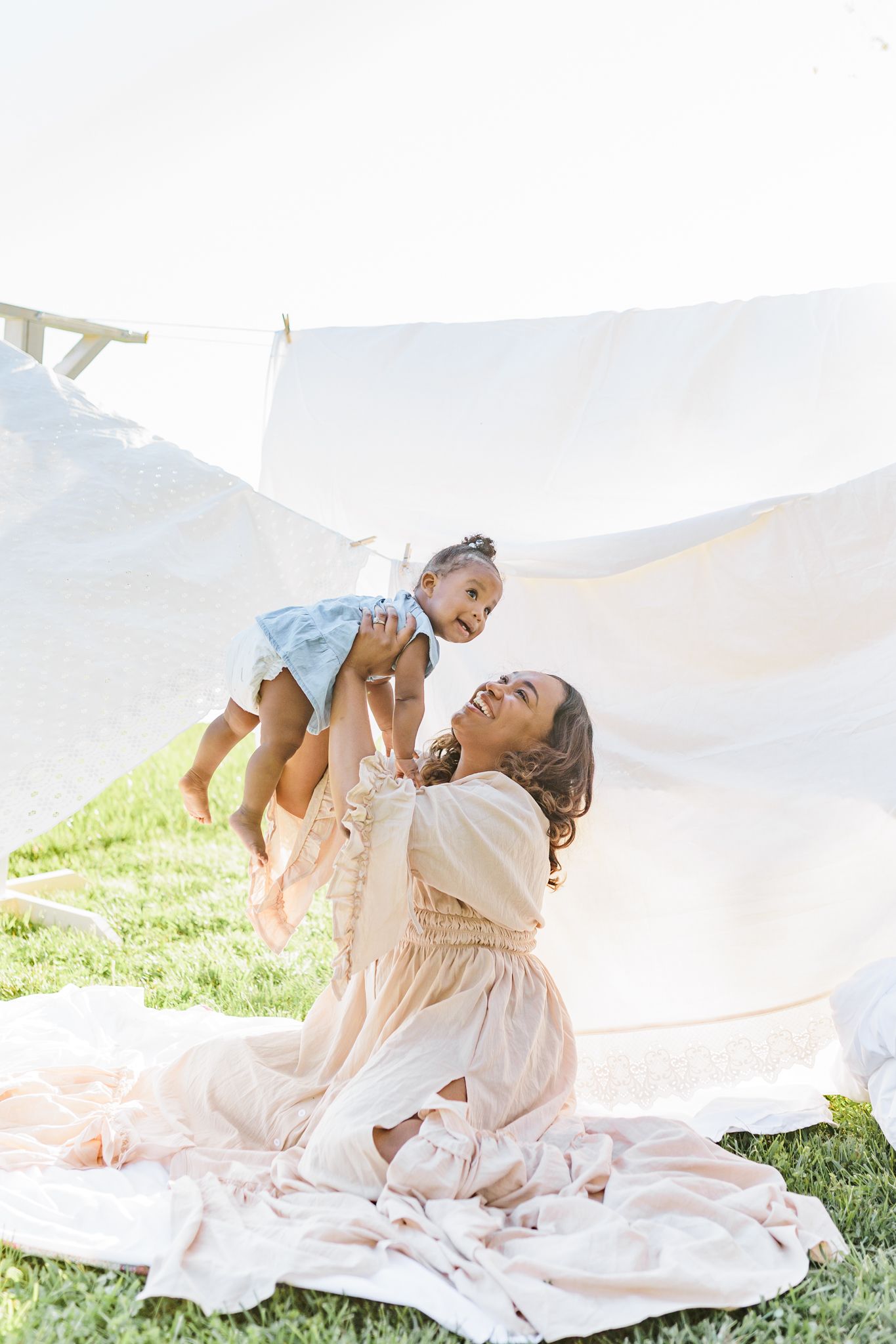 Playful family moments captured on white blanket in outdoor setting  in Winston Salem NC  with a Family Photographer