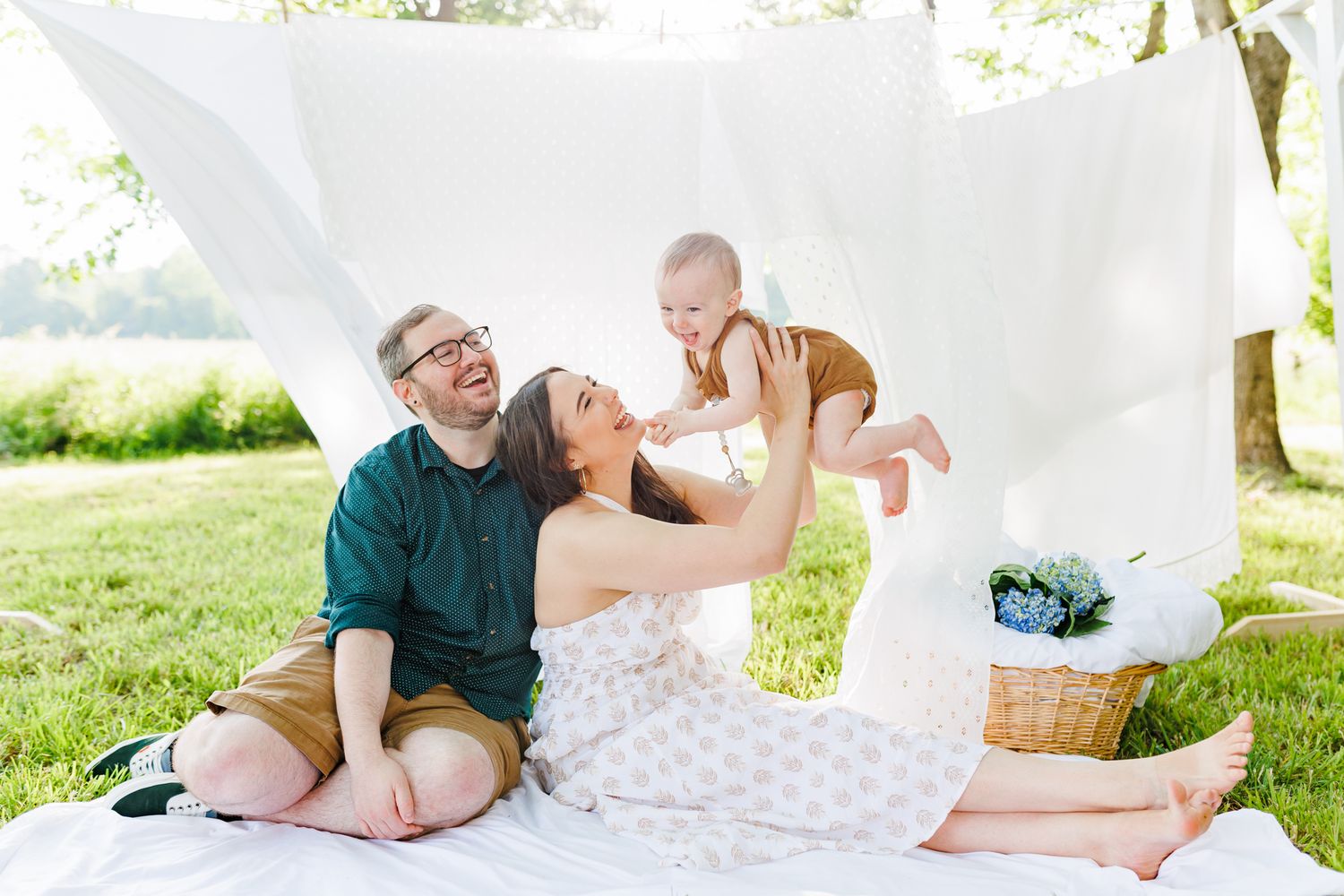 Tender family moment captured on white blankets during outdoor photography session  in Winston Salem NC  with a Family Photographer