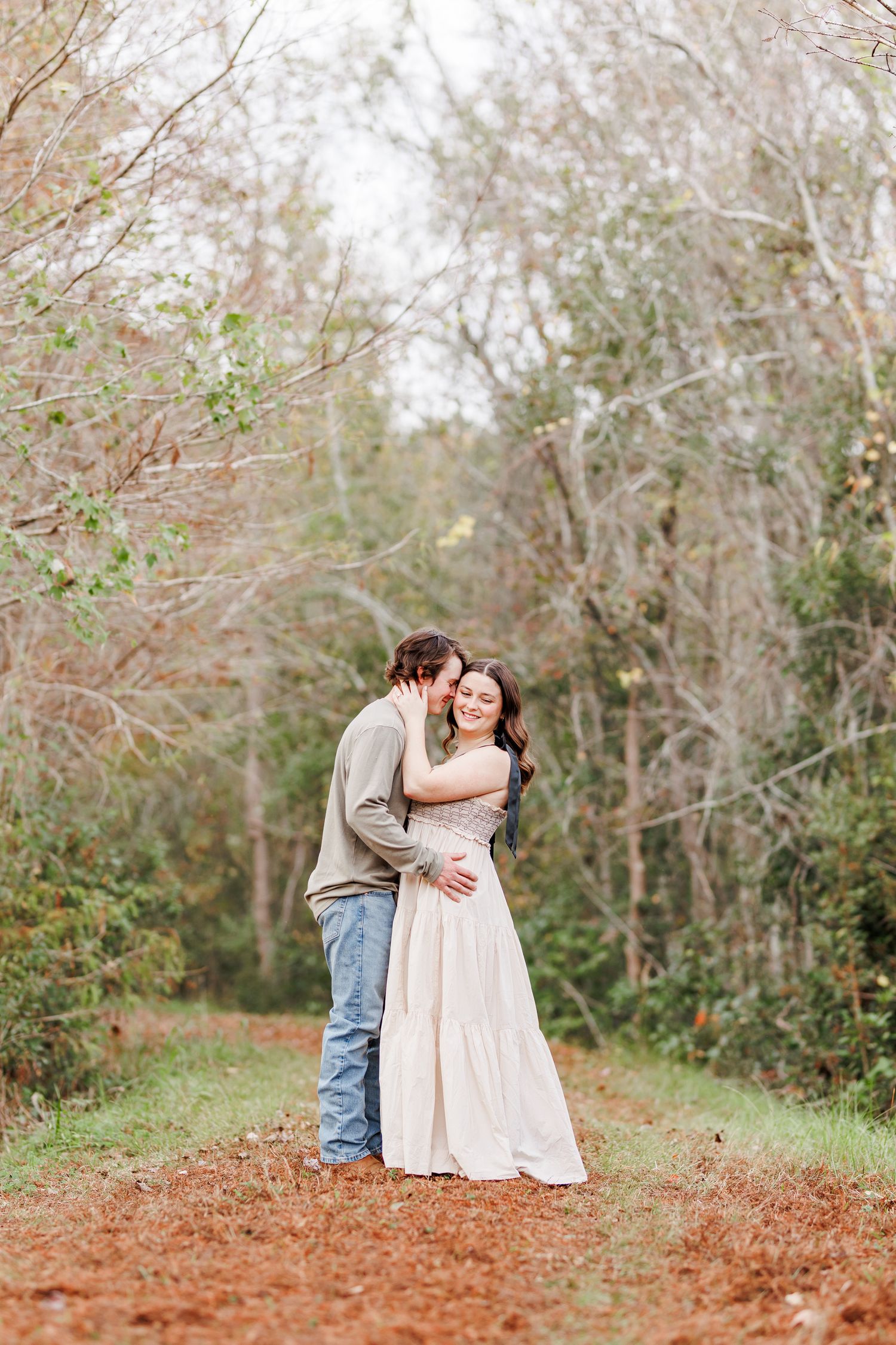 Romantic engagement photos on a nature trail surrounded by autumn trees with Eastern NC Engagement Photographer