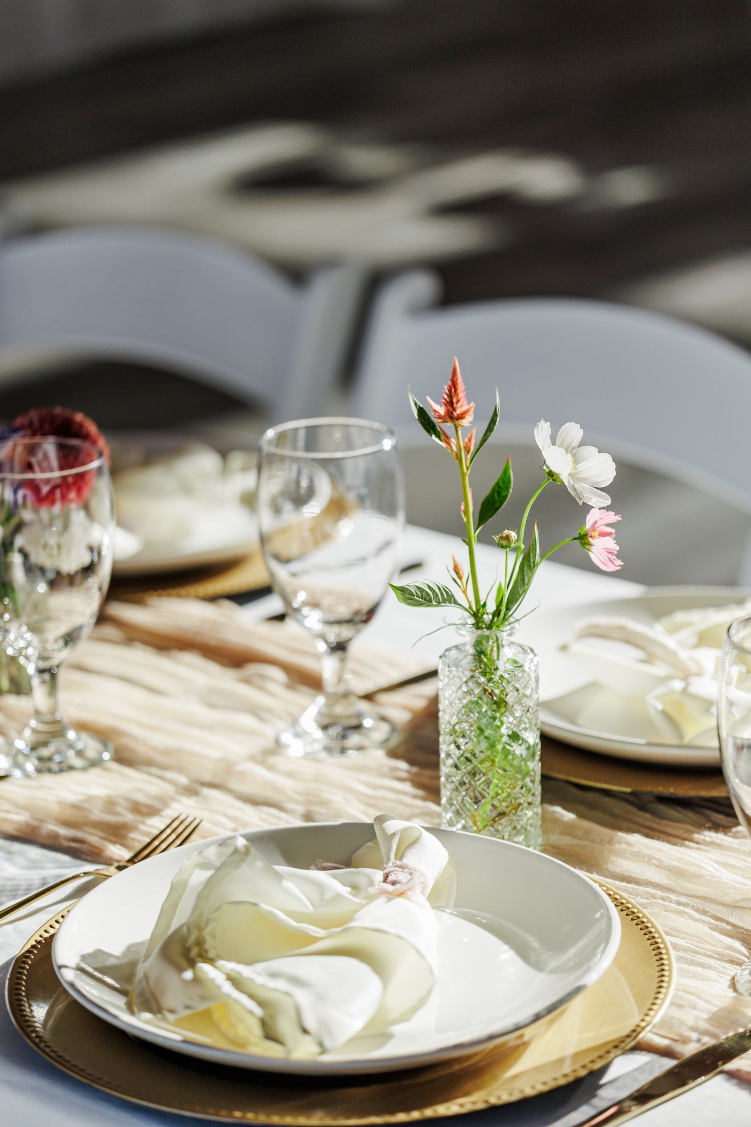 Elegant table settings with gold chargers, white linens, and delicate floral centerpieces at a wedding reception at Appalachian View Venue