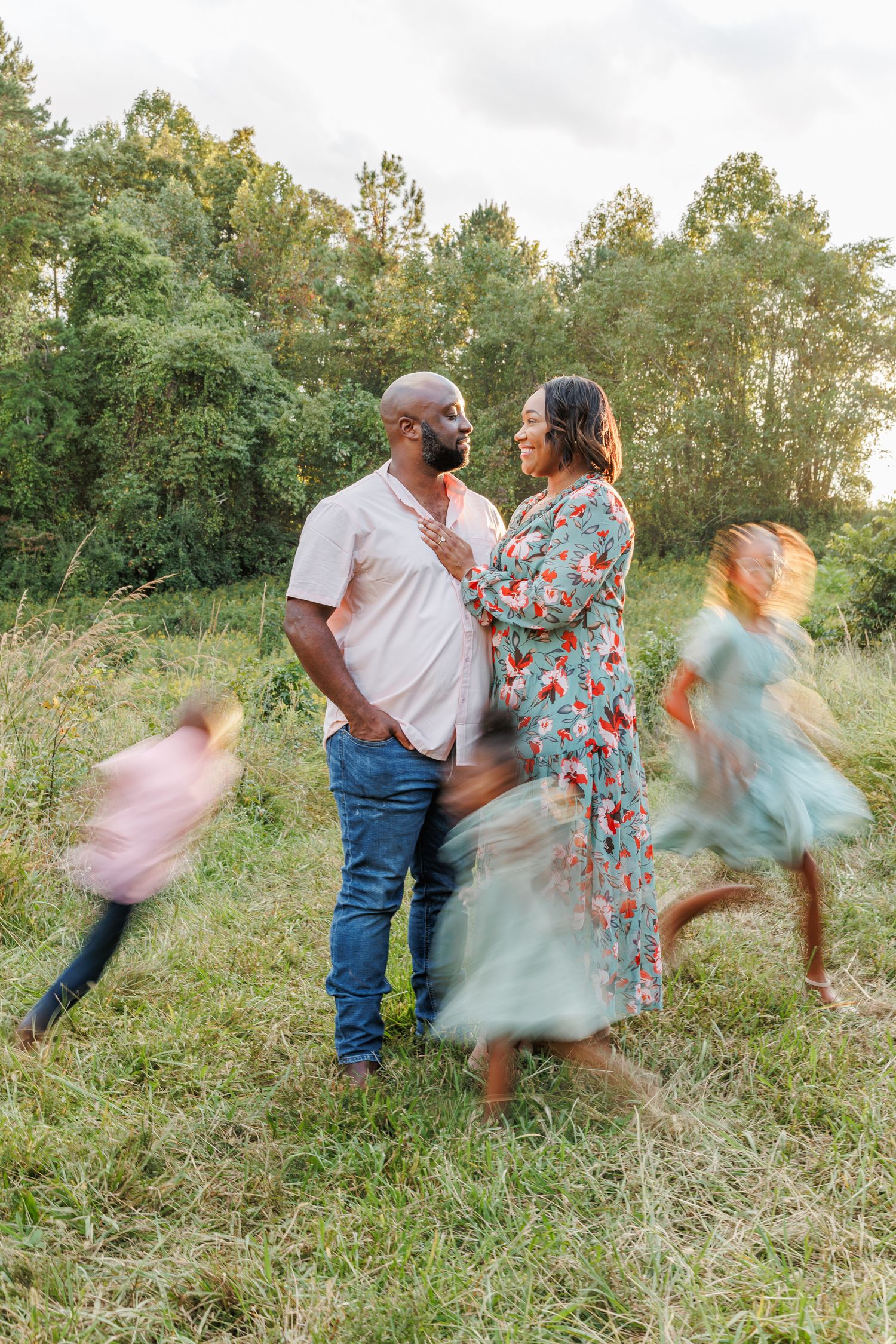 Family playing and twirling in grassy field during golden hour in Greensboro NC with Family Photographer