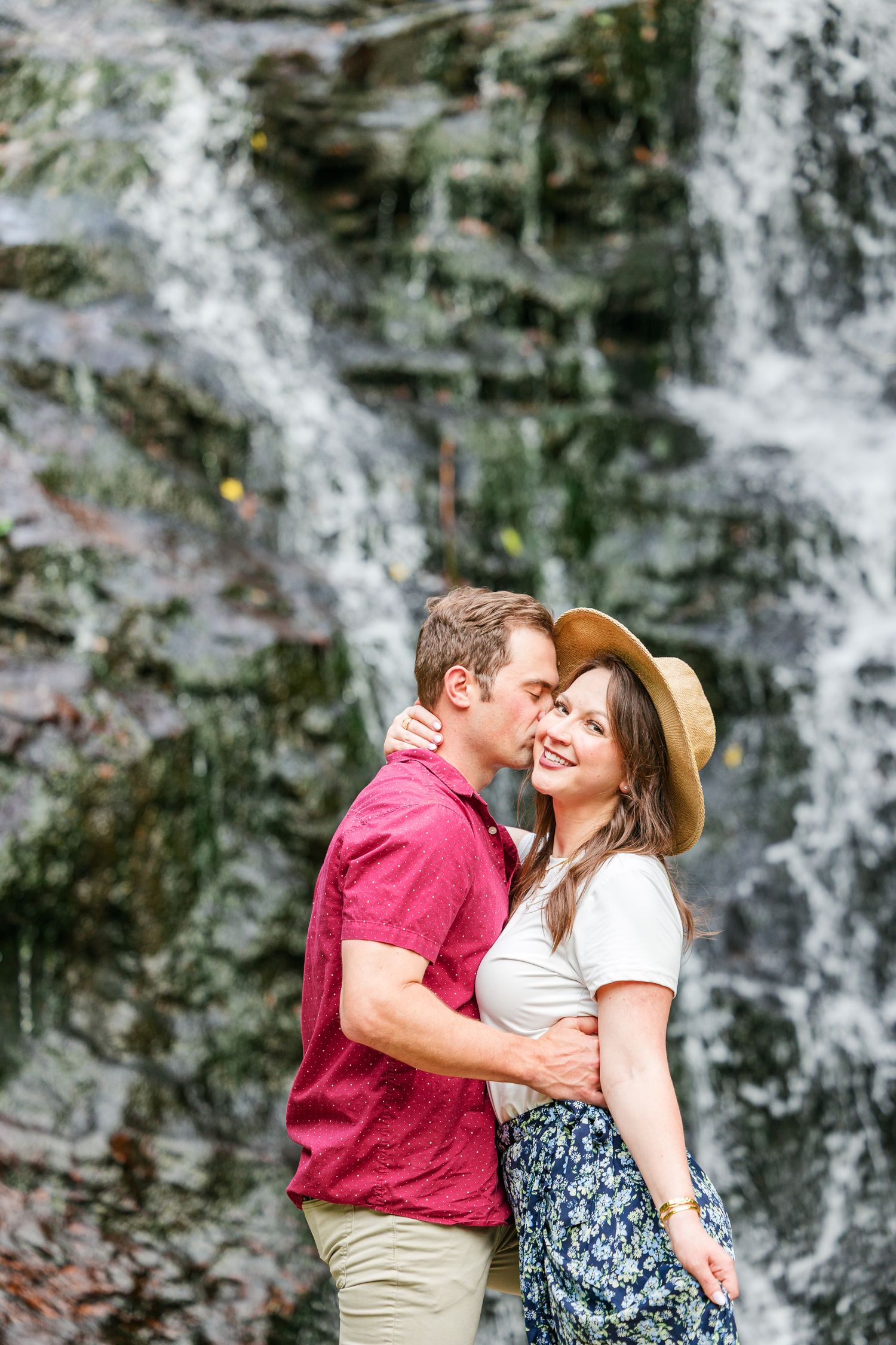 Couple sharing a romantic moment by a cascading waterfall.