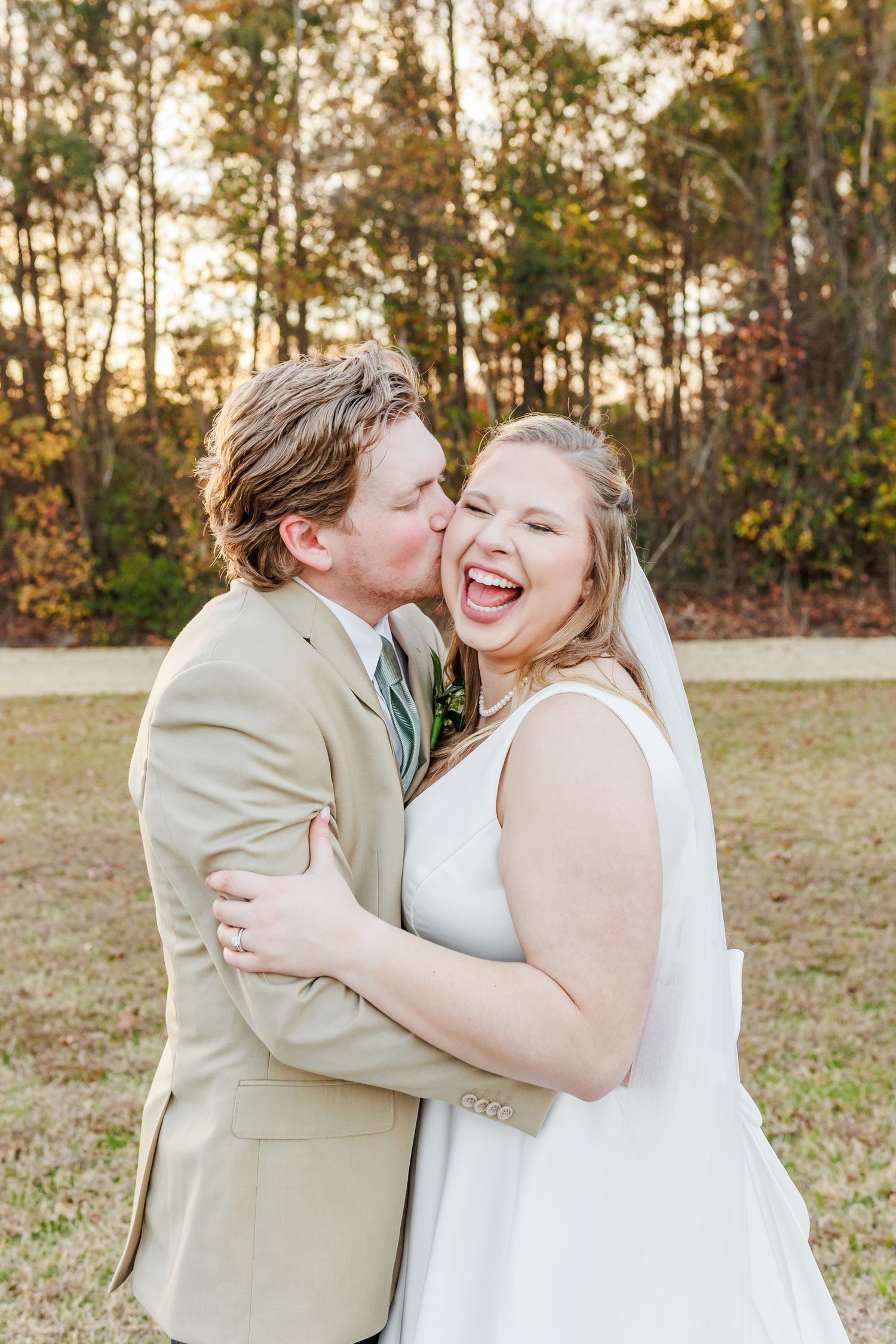 Wedding couple sharing joyful moments during their outdoor autumn photoshoot.