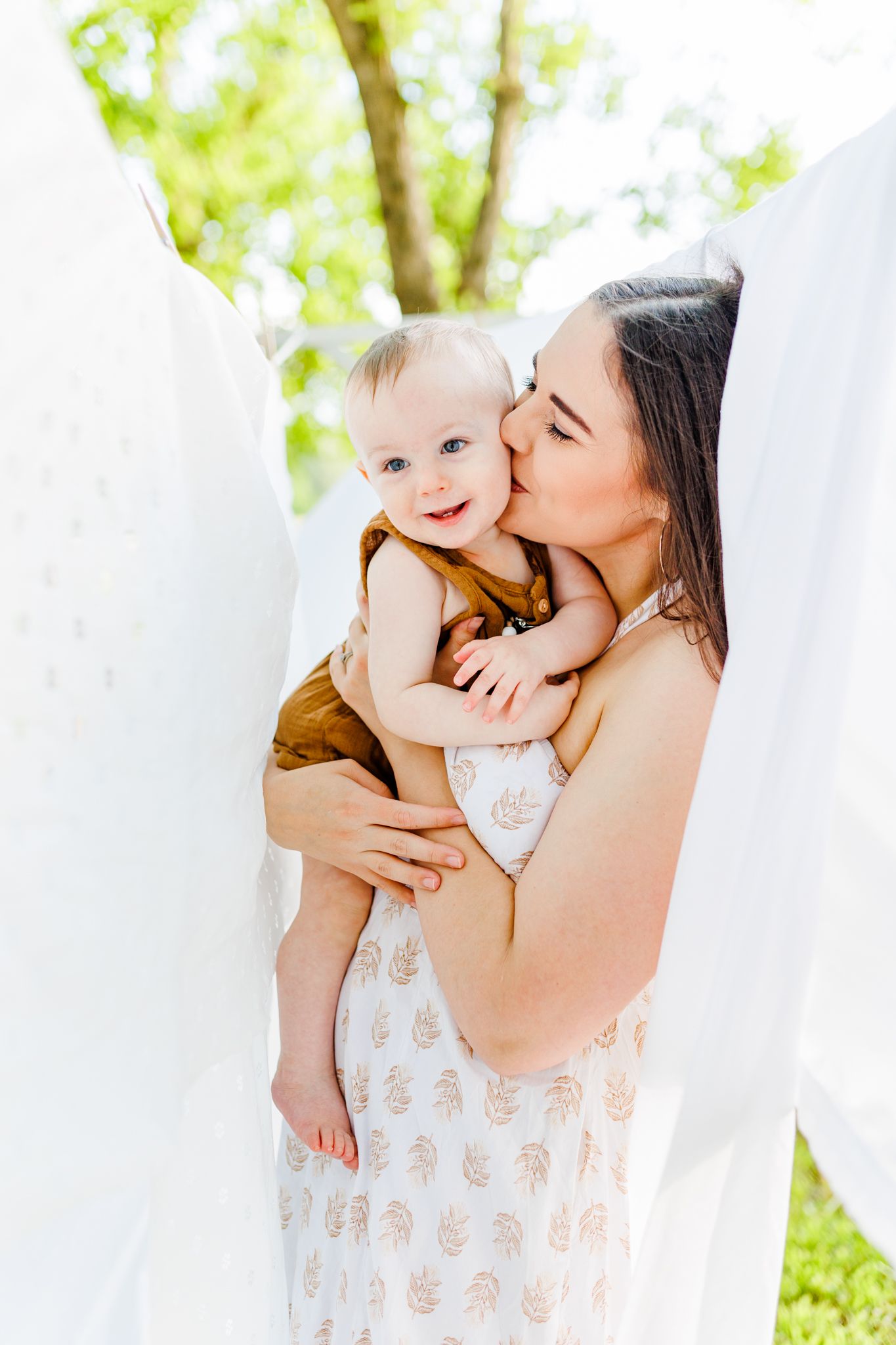 Intimate family moments captured between white curtains in natural outdoor lighting  in Winston Salem NC  with a Family Photographer