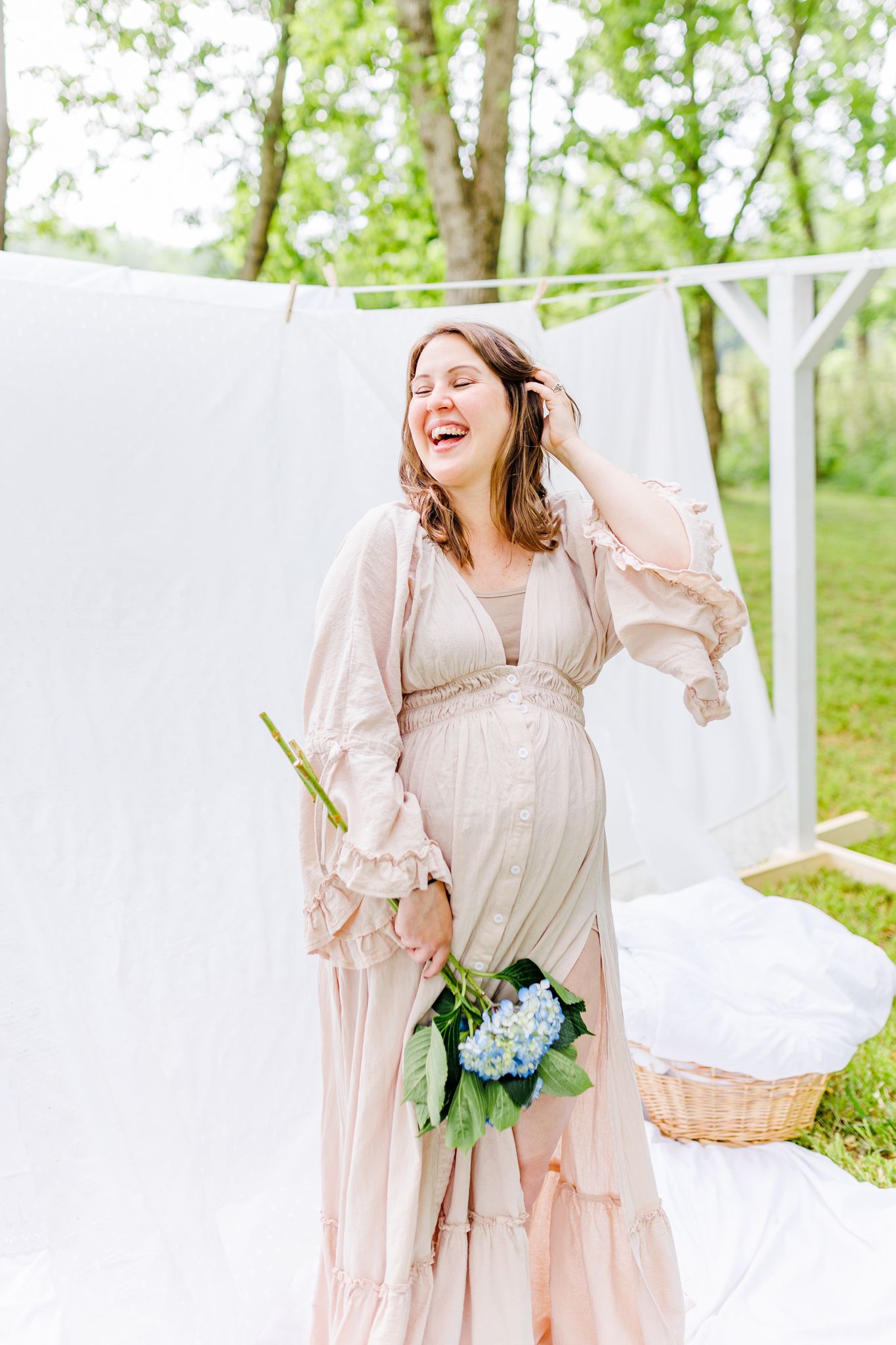 Romantic maternity portraits with white curtains and blue hydrangea flowers in natural lighting in NC  with a Maternity Photographer