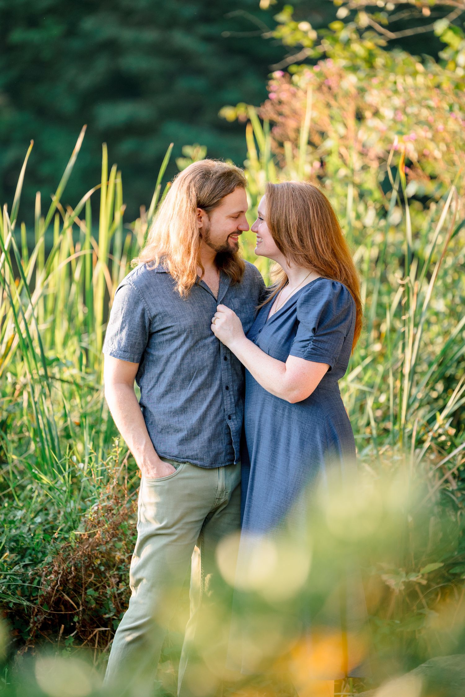 Couple shares tender moments in garden setting with wildflowers and natural light with Raleigh Engagement Photographer