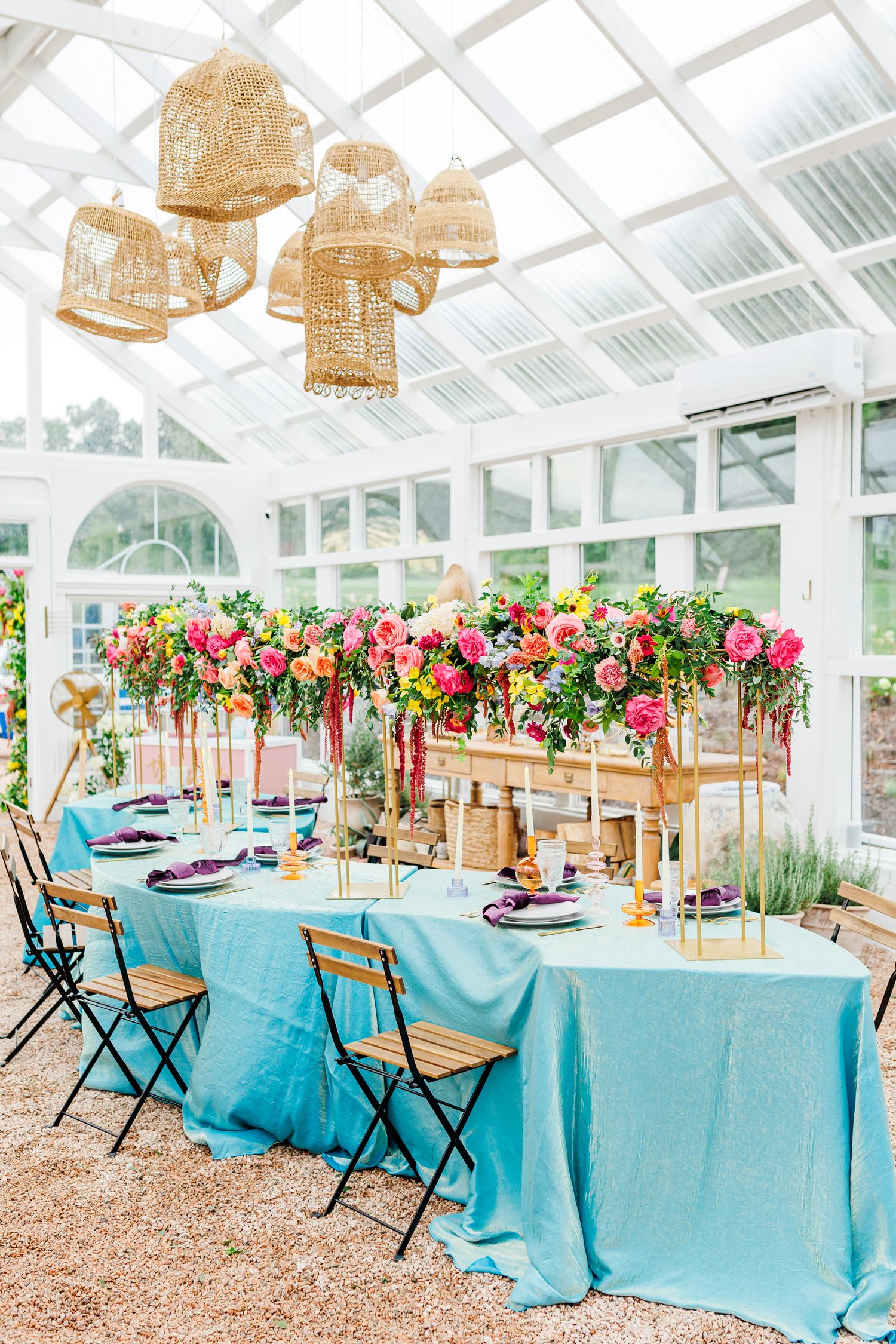 Greenhouse reception setup with turquoise linens and hanging floral arrangements creates tropical ambiance with Winston Salem Wedding photog