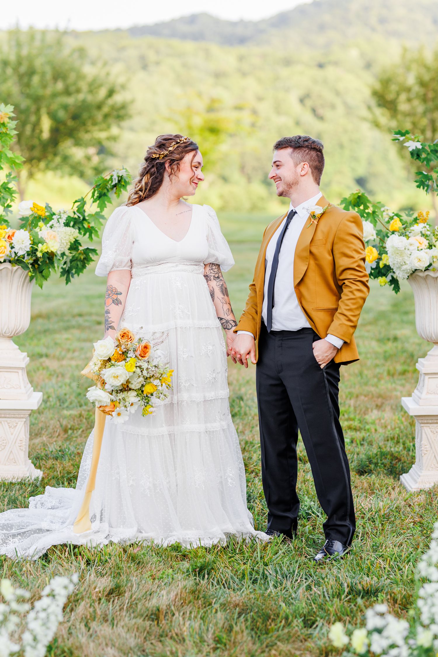 Wedding couple poses in outdoor garden setting with floral decorations.