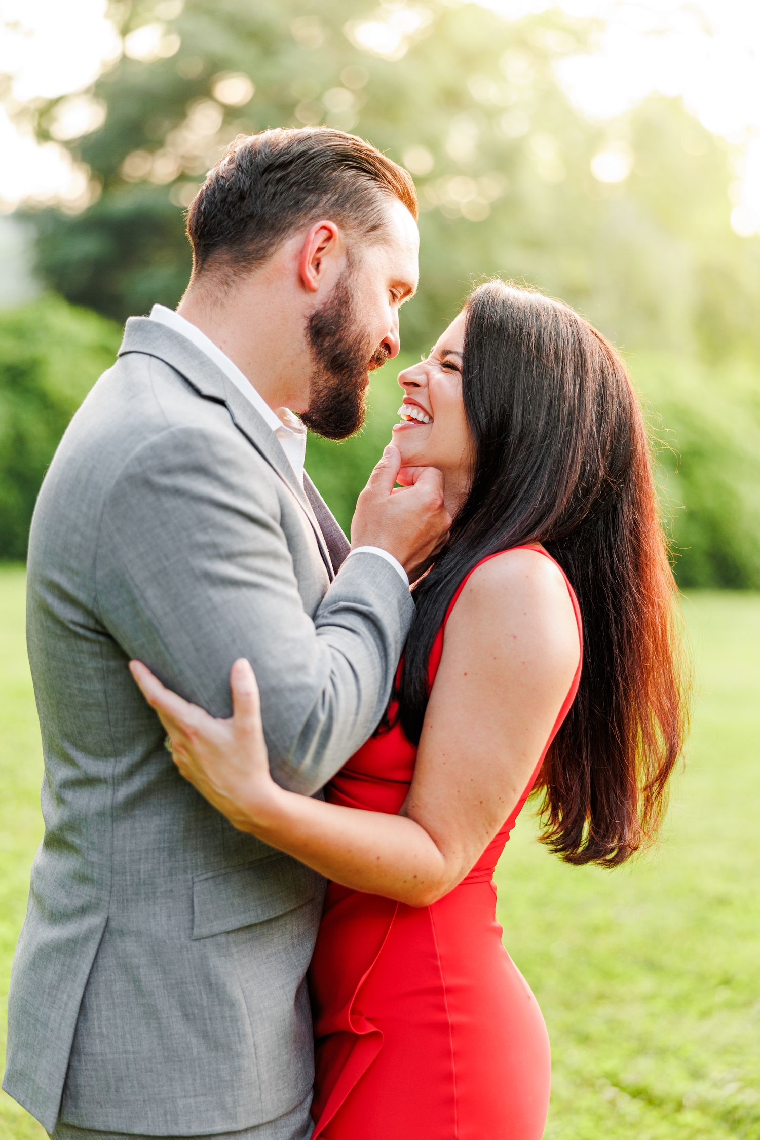 Couple in formal wear sharing romantic moments in a sunlit garden setting at Tanglewood Park