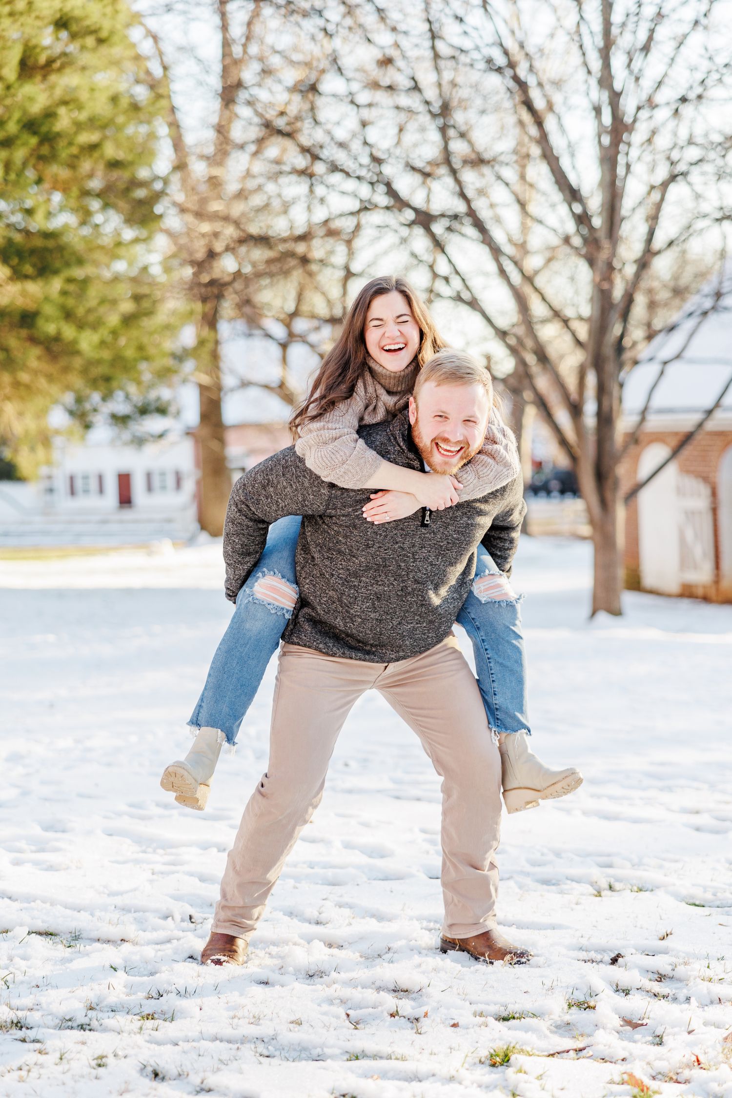 A joyful piggyback ride moment captured in a snowy winter setting with Winston Salem Engagement Photographer