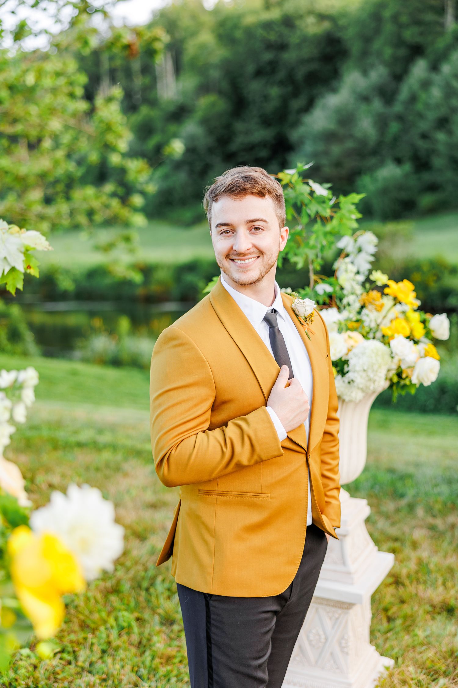 Wedding attire featuring bright mustard yellow suit jacket in garden setting.