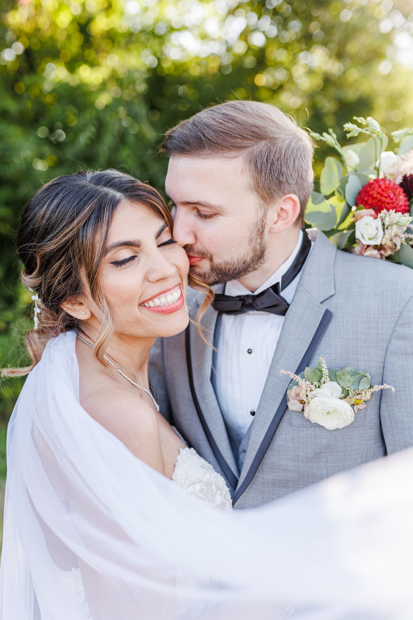 Intimate wedding portrait with soft white veil and delicate floral bouquet details  with NC Wedding Photographer