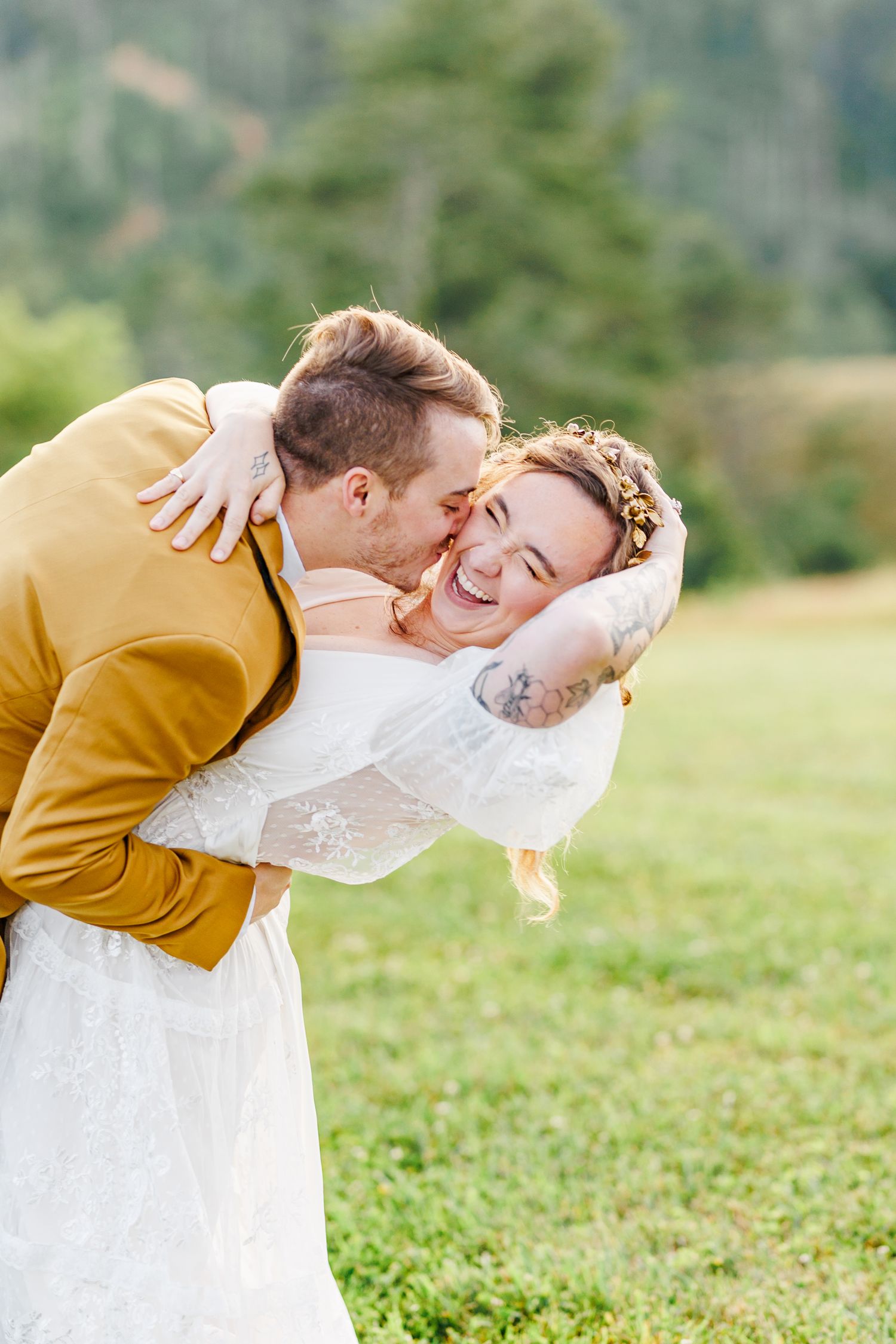 Romantic wedding couple embracing in a grassy field during golden hour at the Barn at New River with NC Wedding Photographer