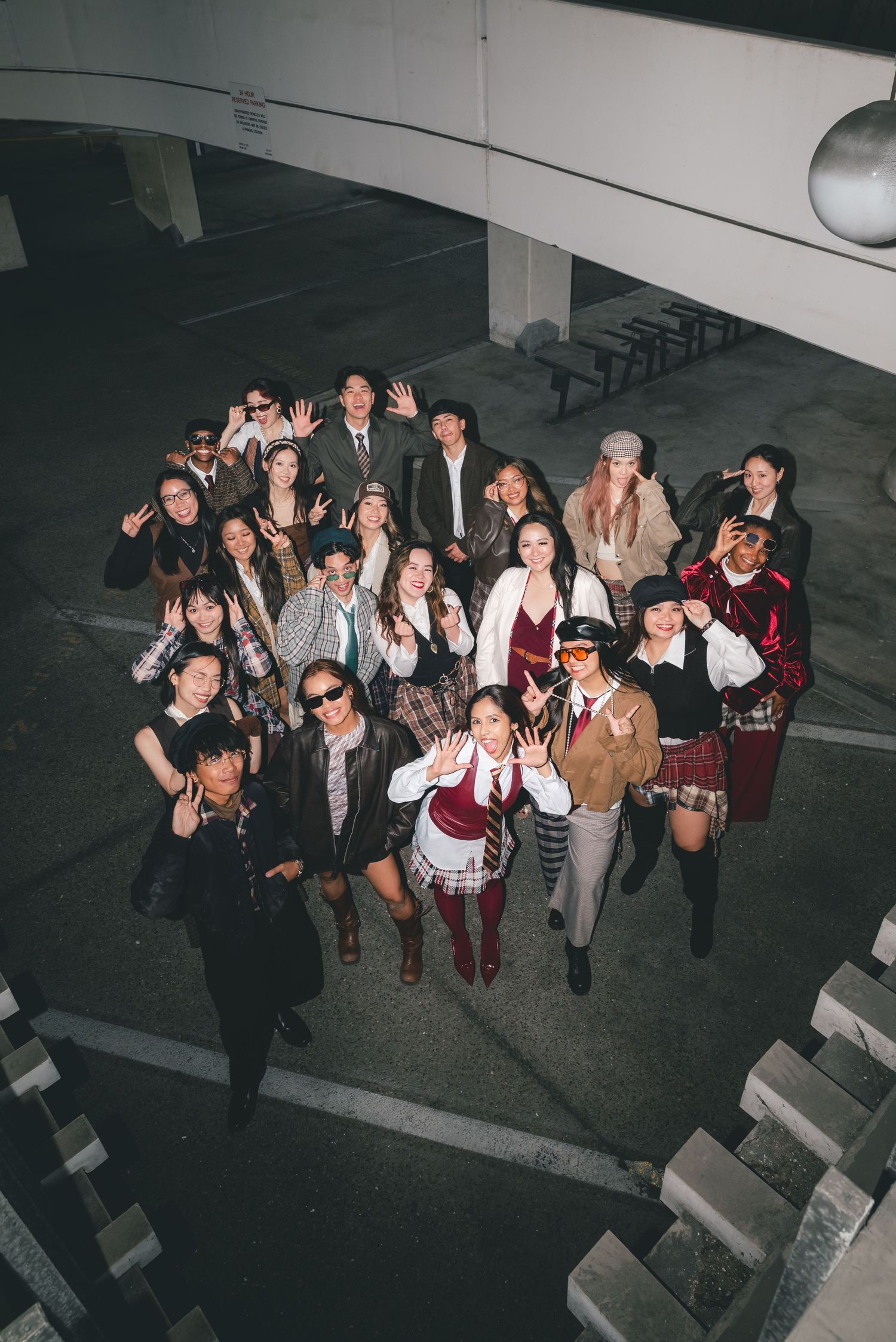 Portrait looking downward at a group of dance team members in coordinating business casual outfits and playfully posing with each other.