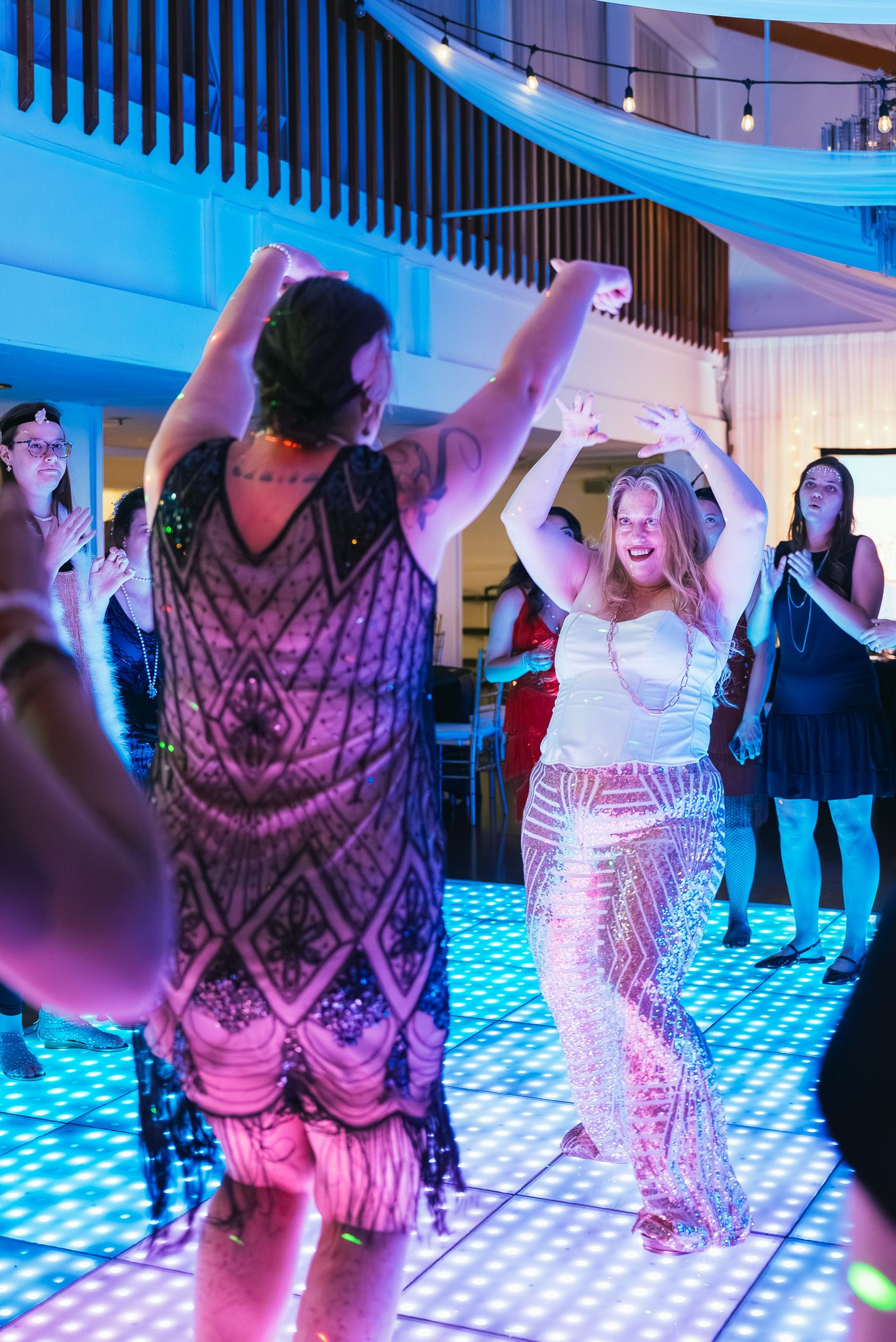 Full-body portrait of two women dancing in front of each other at a 1920s-themed party.