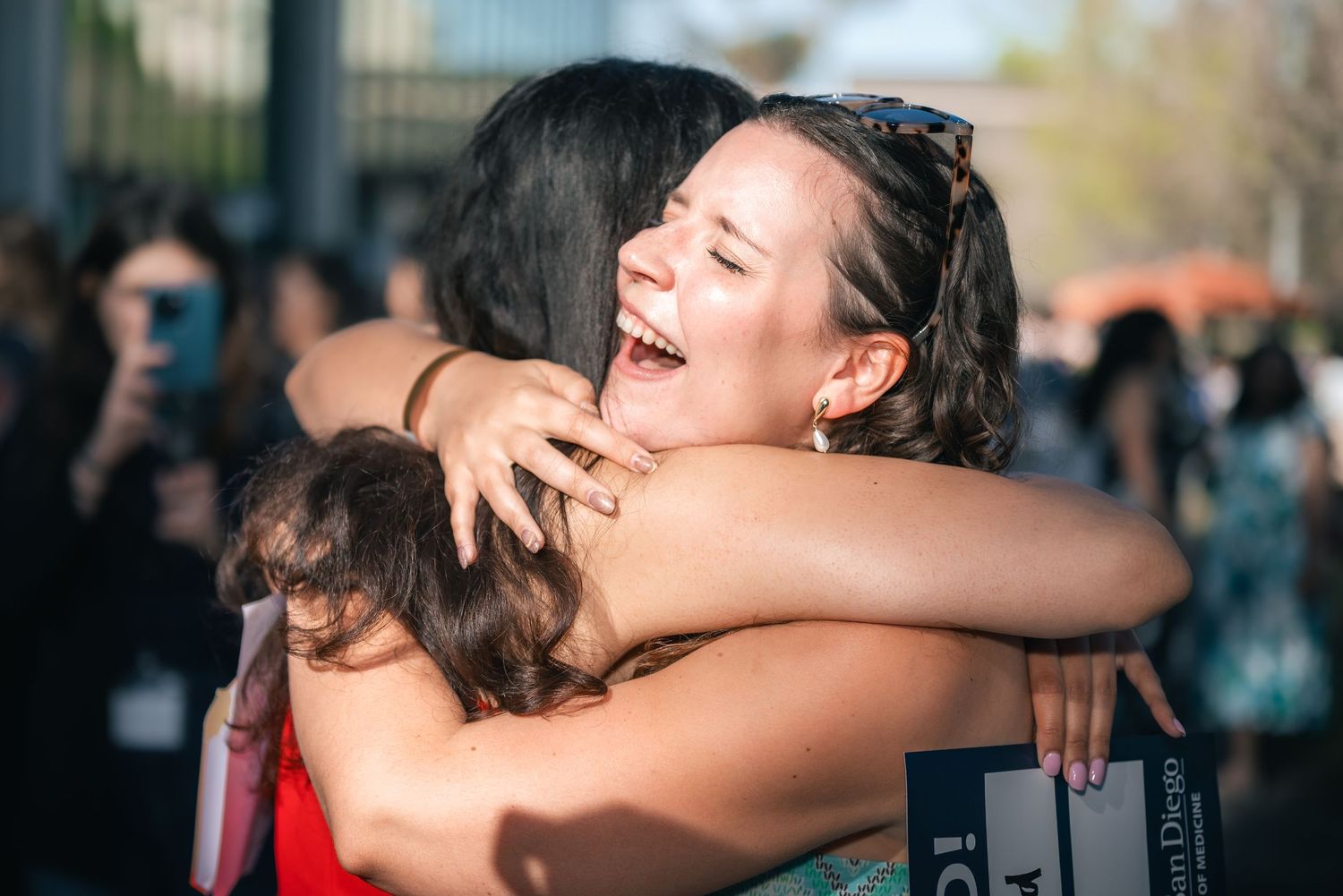 Portrait of two women in embrace as they gleefully celebrate their matching into residency.