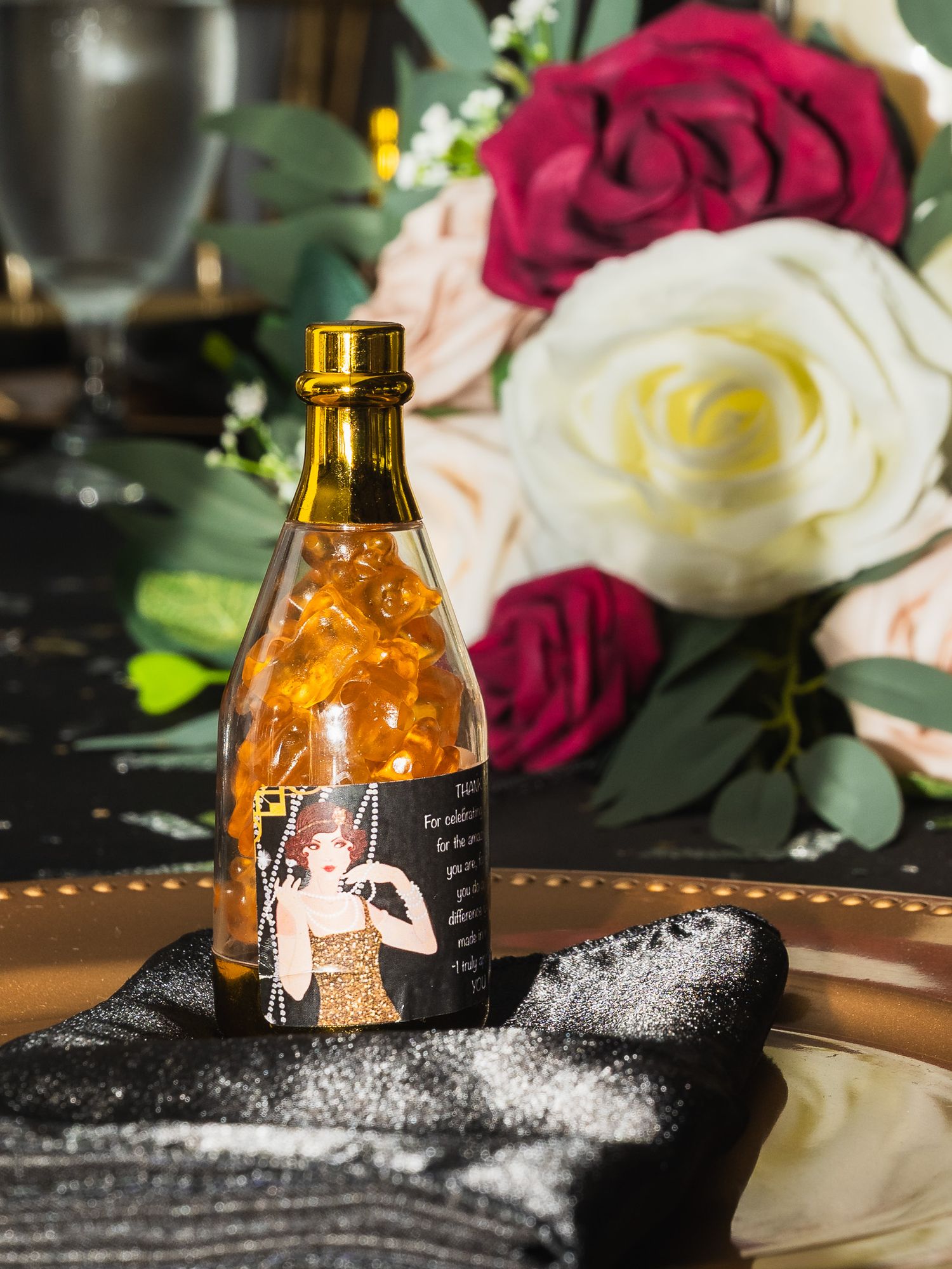 Detail shot of gummy bears in a container shaped as a champagne bottle for a 1920s themed party.