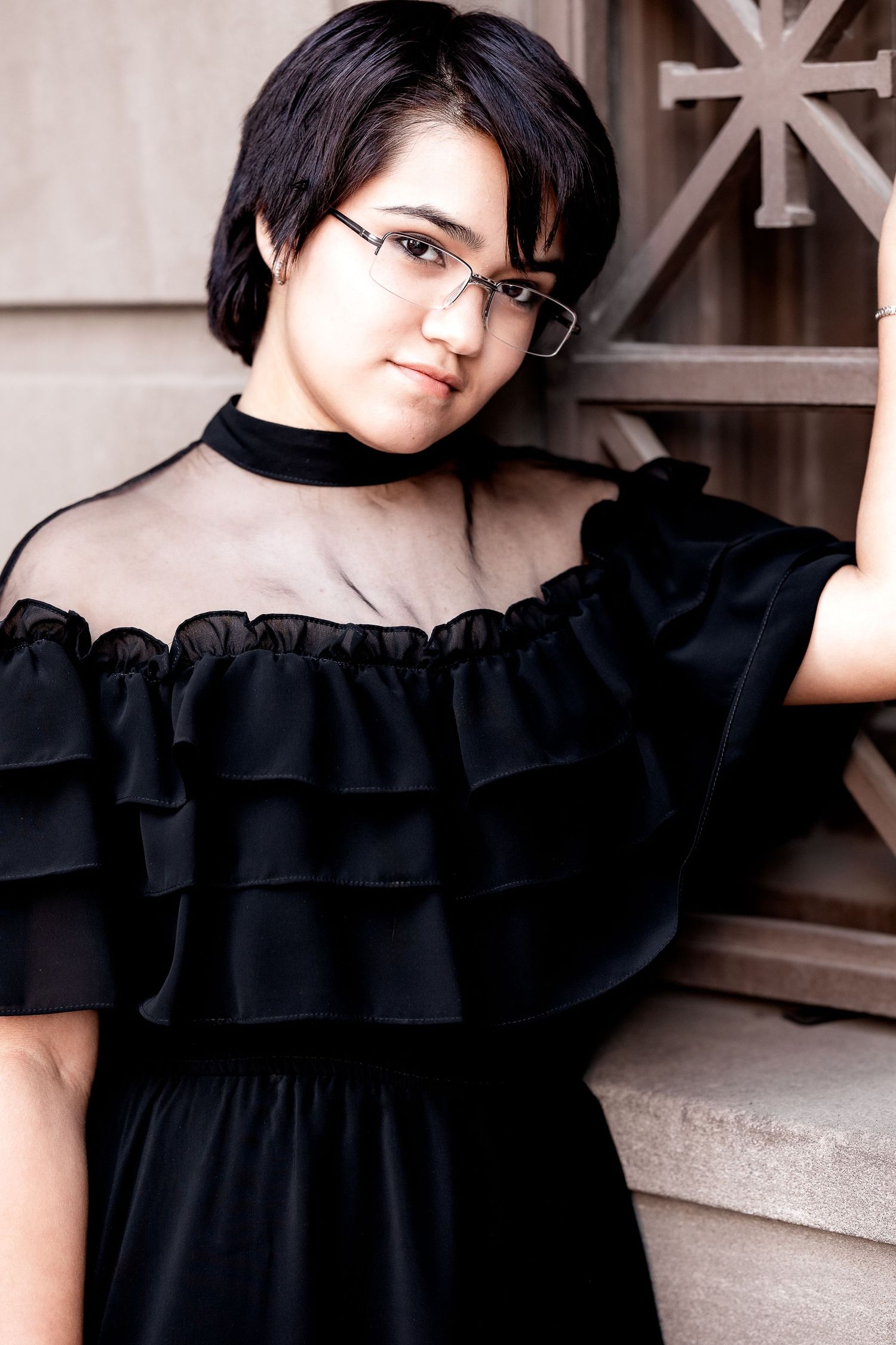 Picture of female high school senior in an urban setting, leaning against a wall.