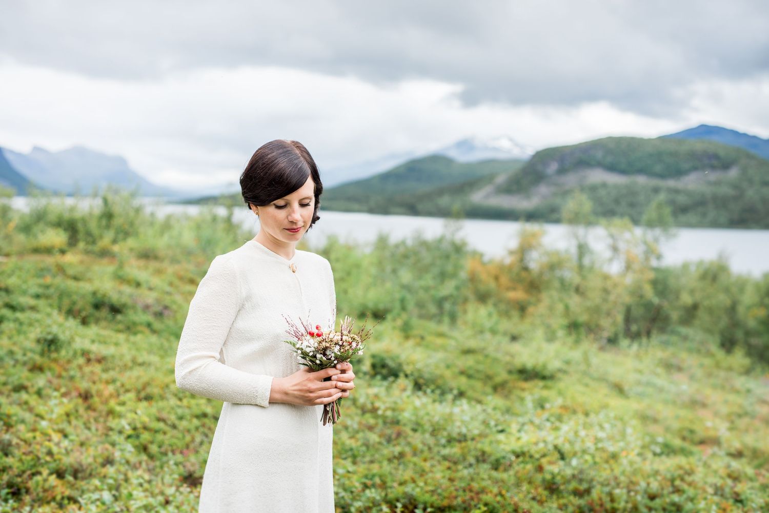 Scenic mountain landscape with rolling hills and cloudy skies serves as backdrop for bridal photography.