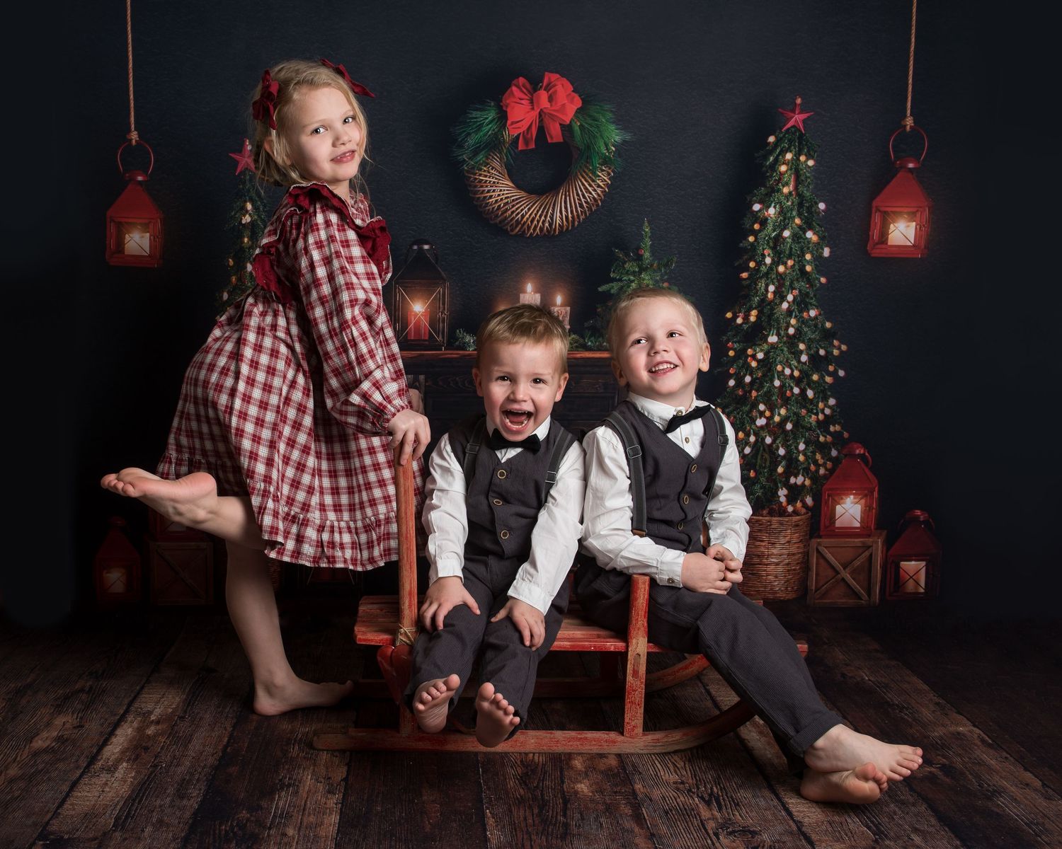 Cozy Christmas scene with a wooden swing, red lanterns, and evergreen decorations in a rustic setting.