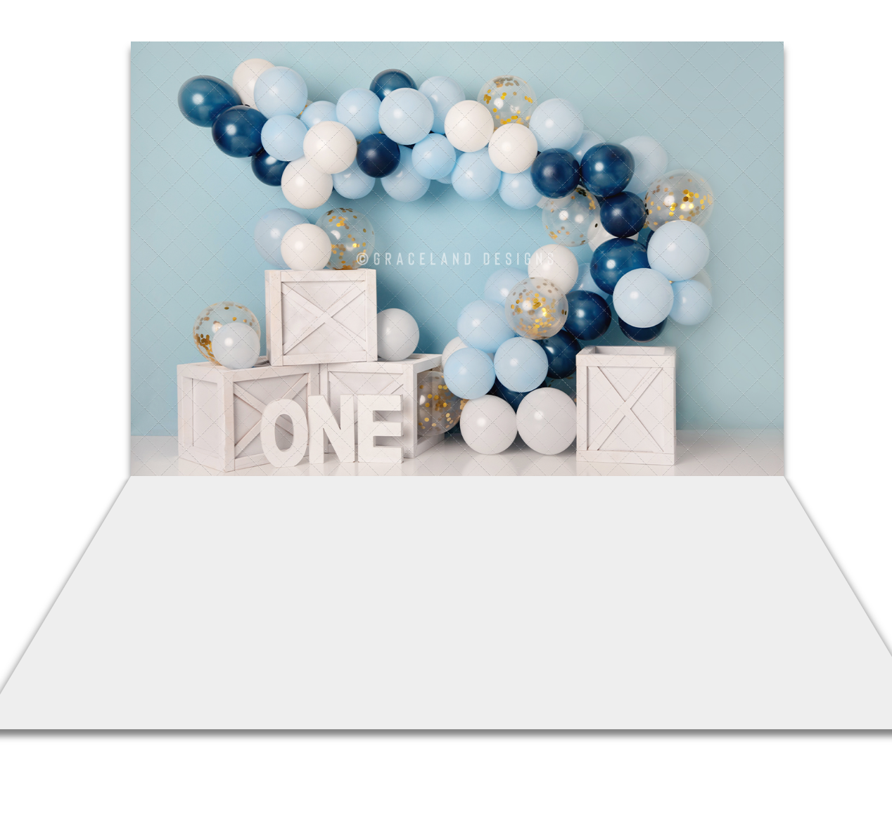 Blue and white balloon arch backdrop with wooden crates spelling ONE, perfect for a first birthday cake smash photo.