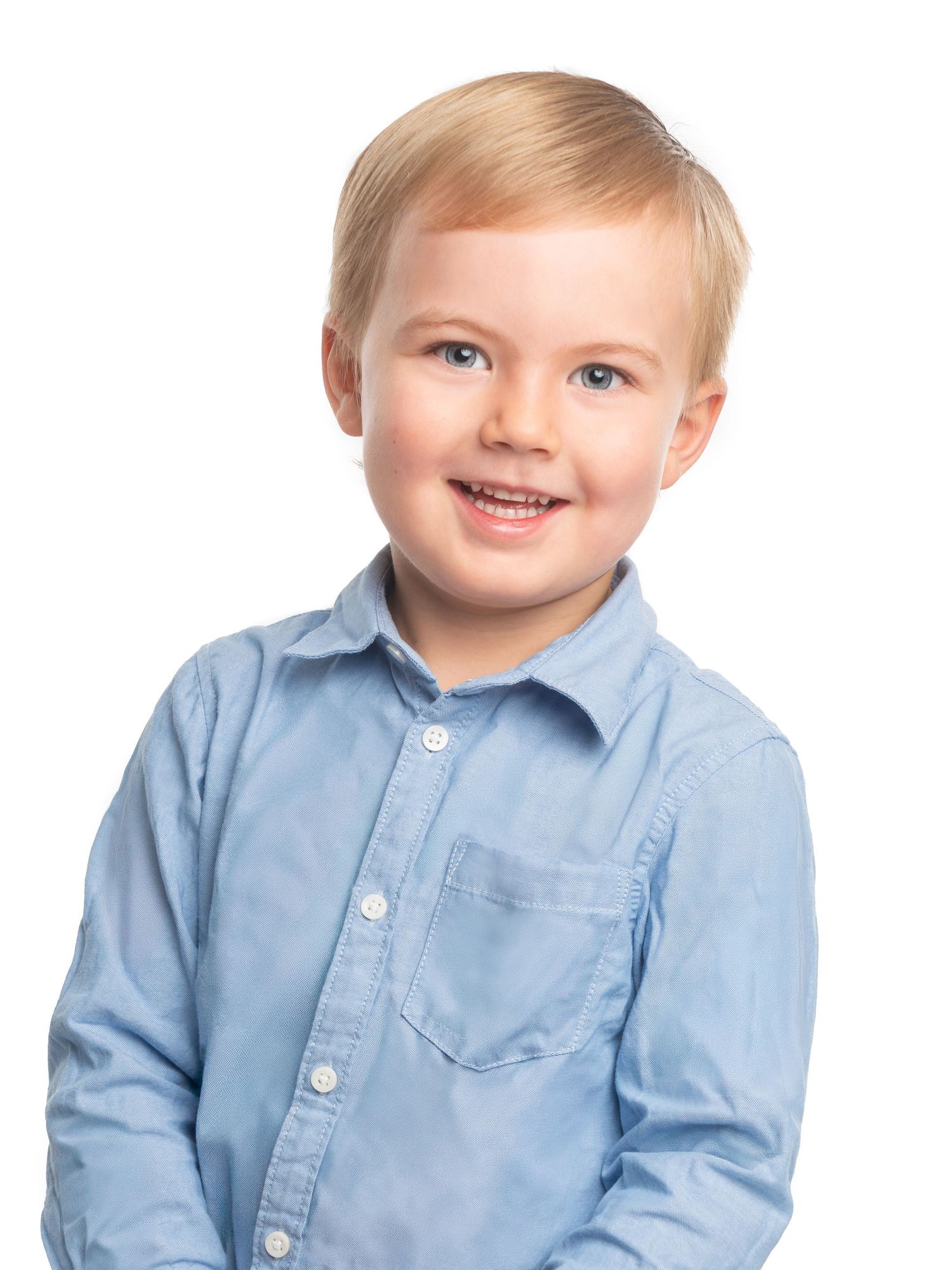 Child in light blue button-up shirt smiling against white background.