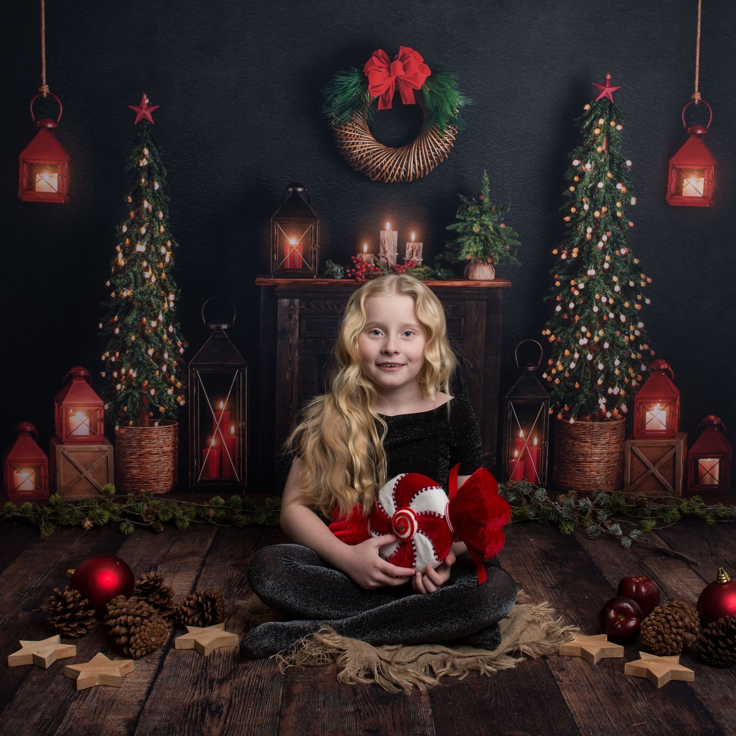 Festive holiday photography scene with illuminated Christmas trees and red decorative accents.