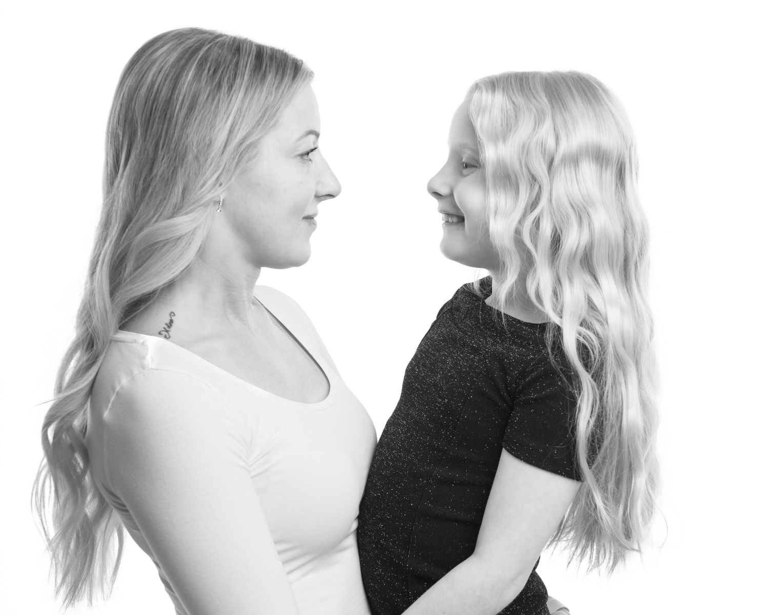 Black and white artistic portrait of mother and daughter in profile.