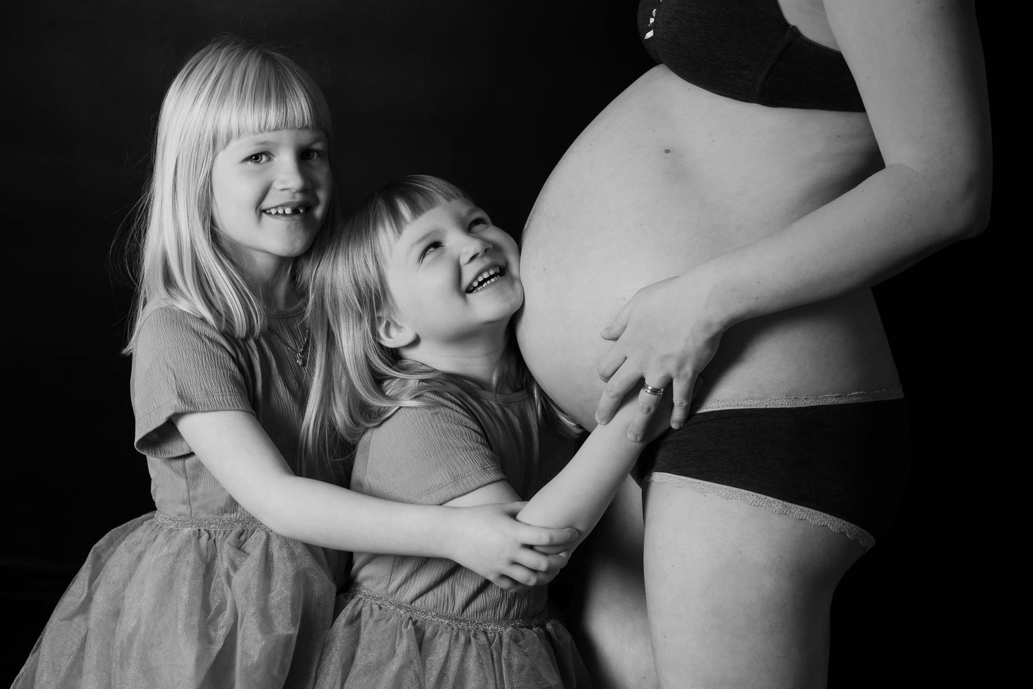 Black and white maternity photos showing interaction with pregnant belly.