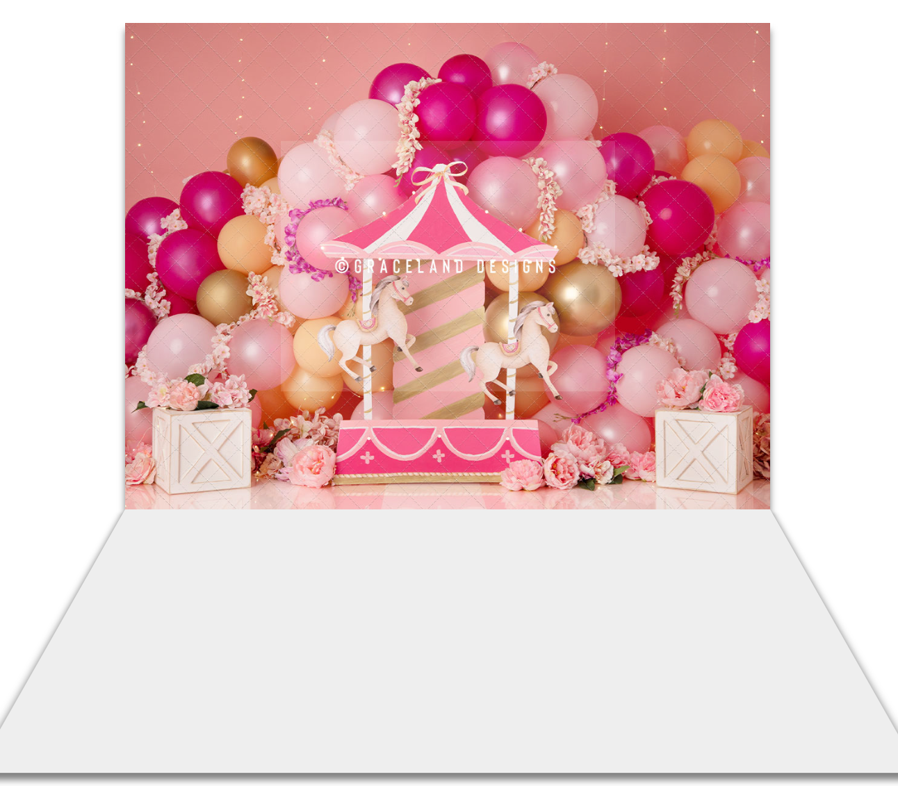 Pink circus carousel birthday backdrop with balloon arch, roses, and wooden crates for party photography.