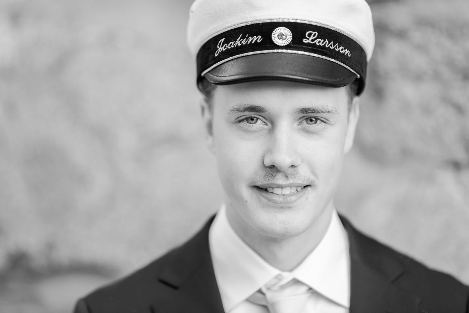 Black and white portrait of someone wearing a sailor cap and formal attire.