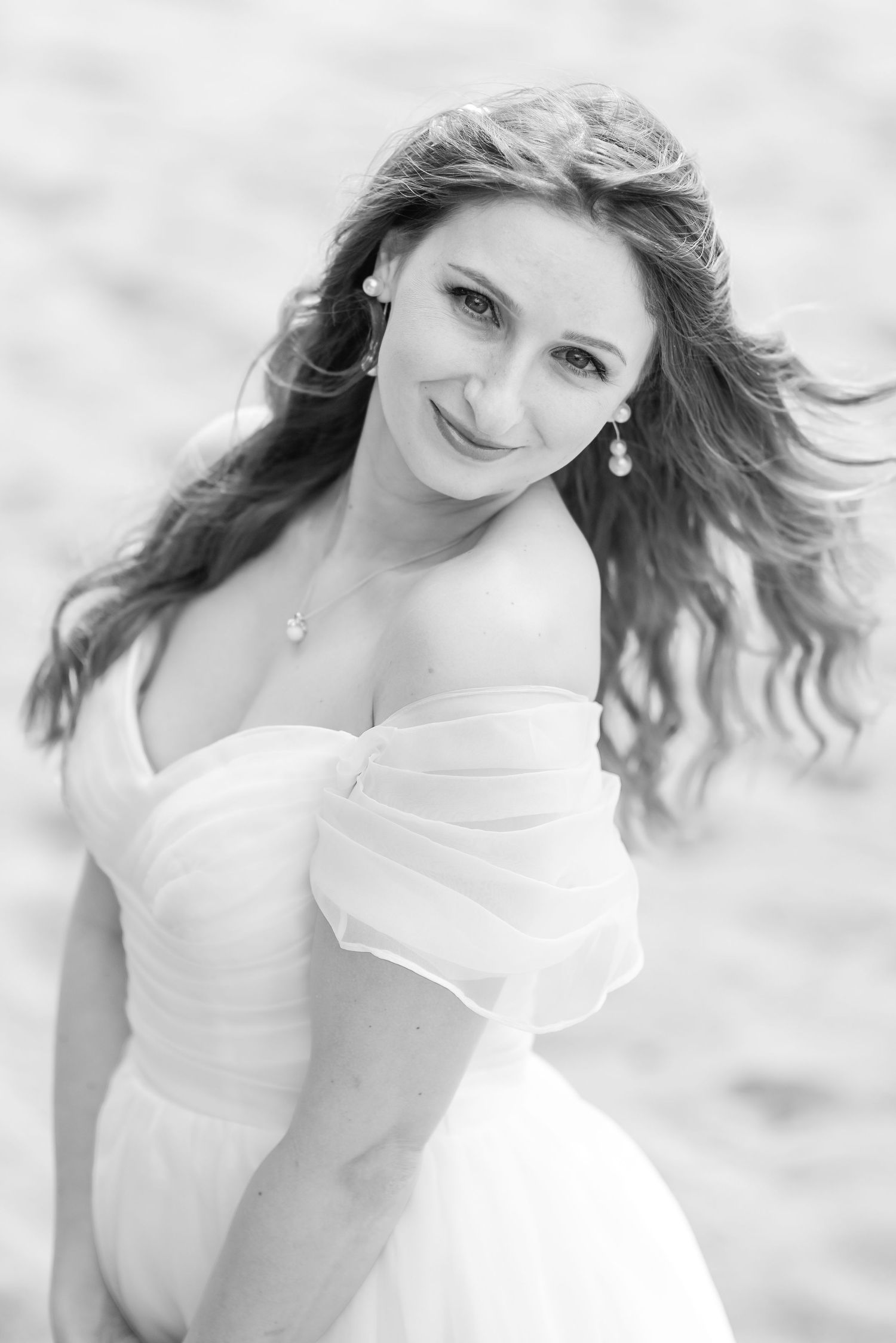 Artistic black and white bridal portraits with flowing hair and romantic lighting.