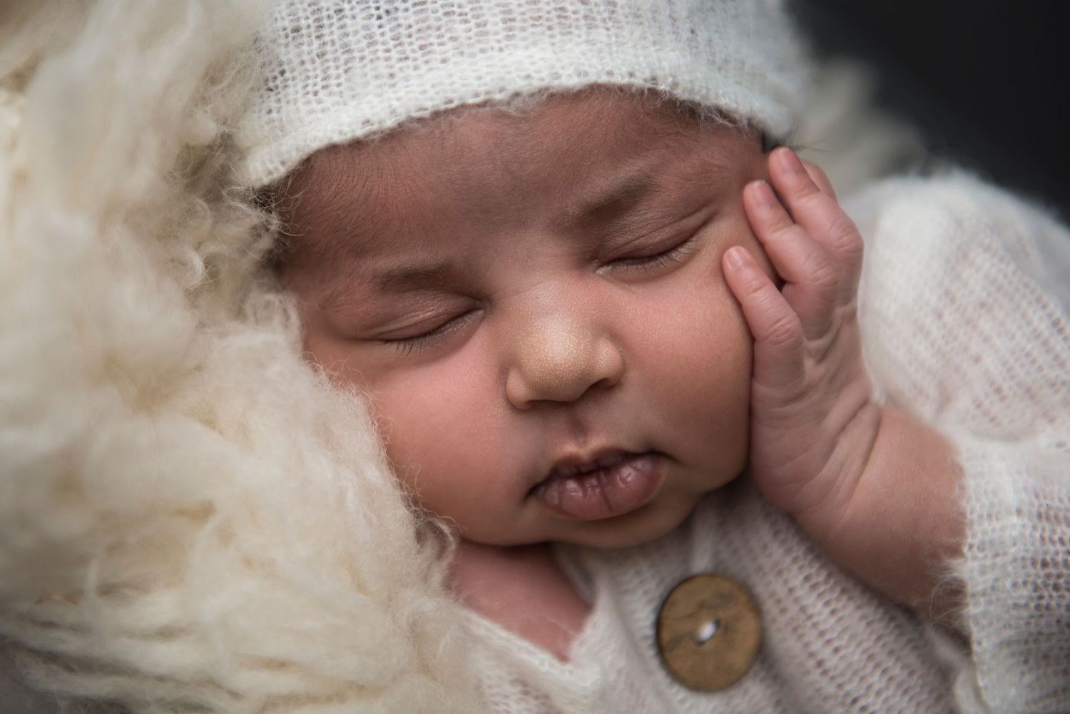 Peaceful newborn photography session featuring soft white fabrics and delicate lighting.