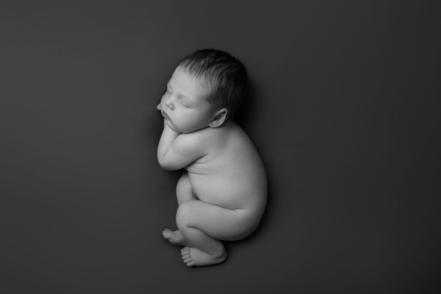 Artistic black and white newborn photography sequence showing different poses of a sleeping baby.