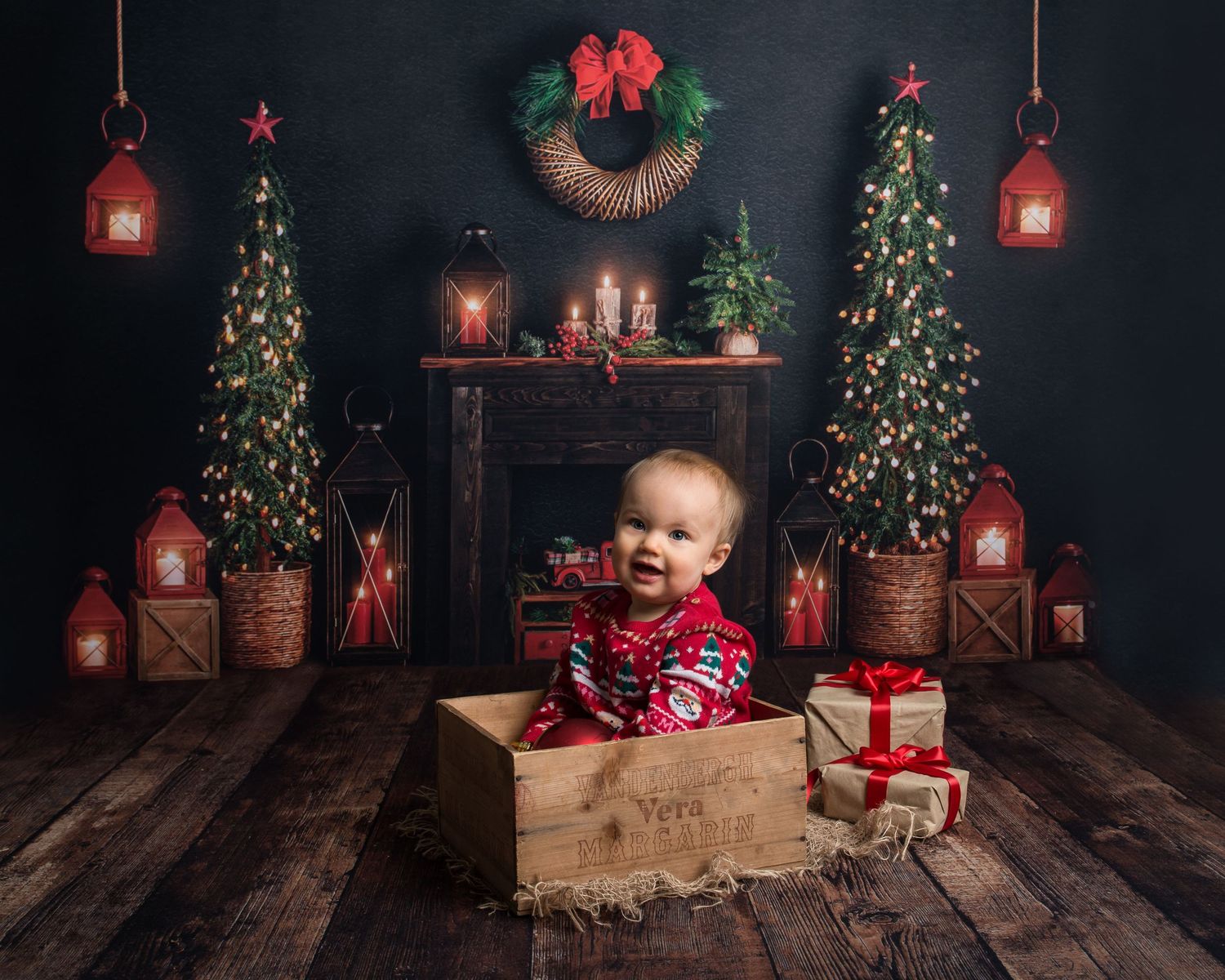 Cozy Christmas photo setup with lanterns, wooden crates and festive holiday decorations.