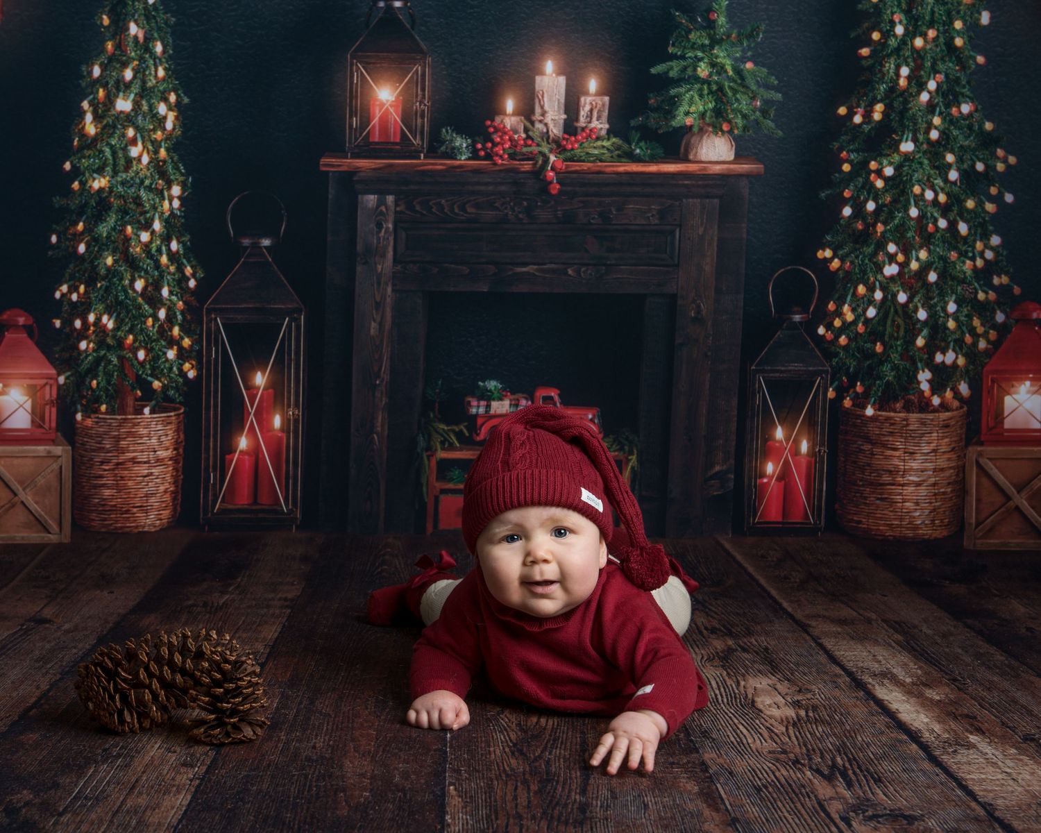 Holiday photo scene with lit Christmas trees, red lanterns and vintage wood flooring.