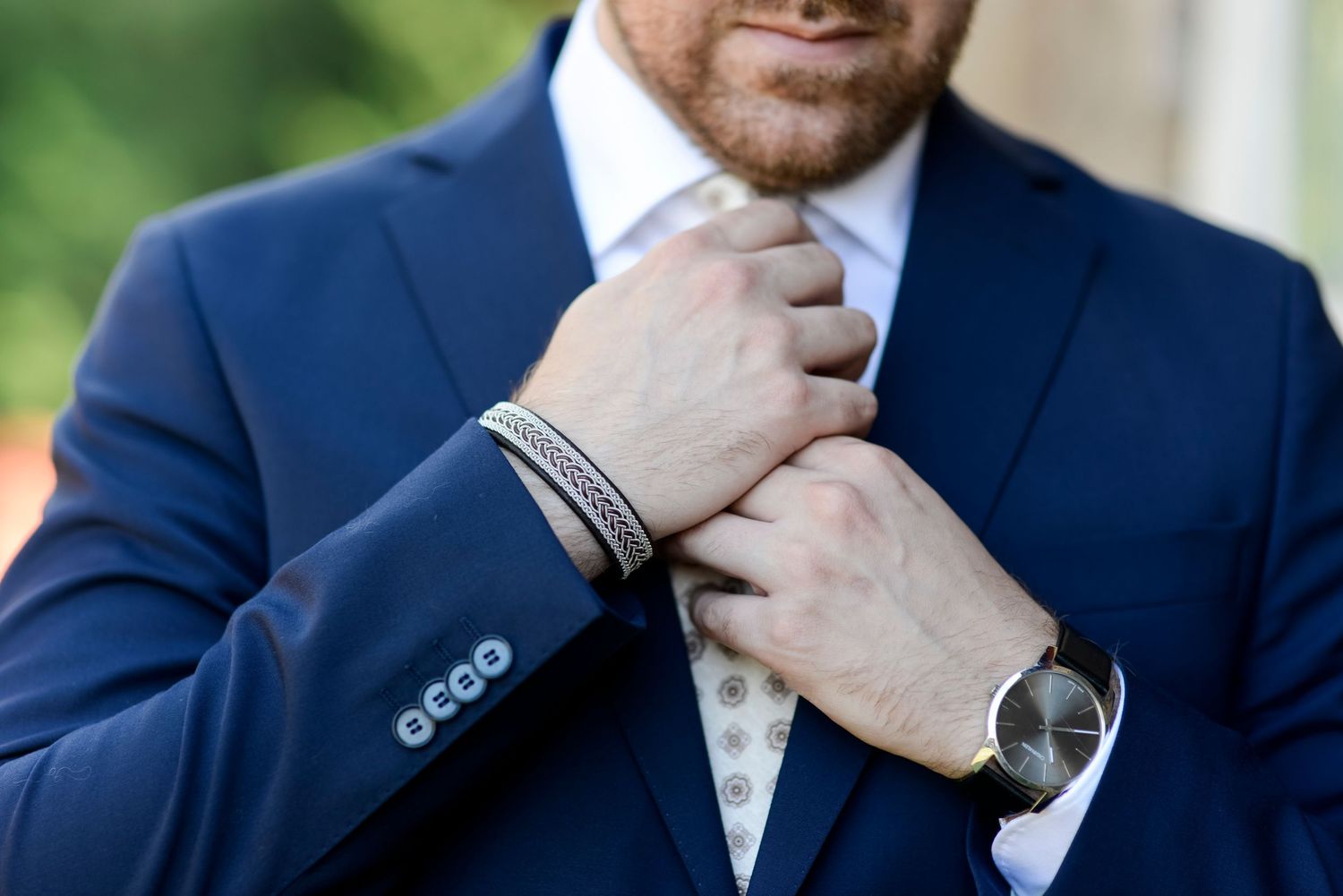 Close-up detail of navy suit jacket and tie adjustments.