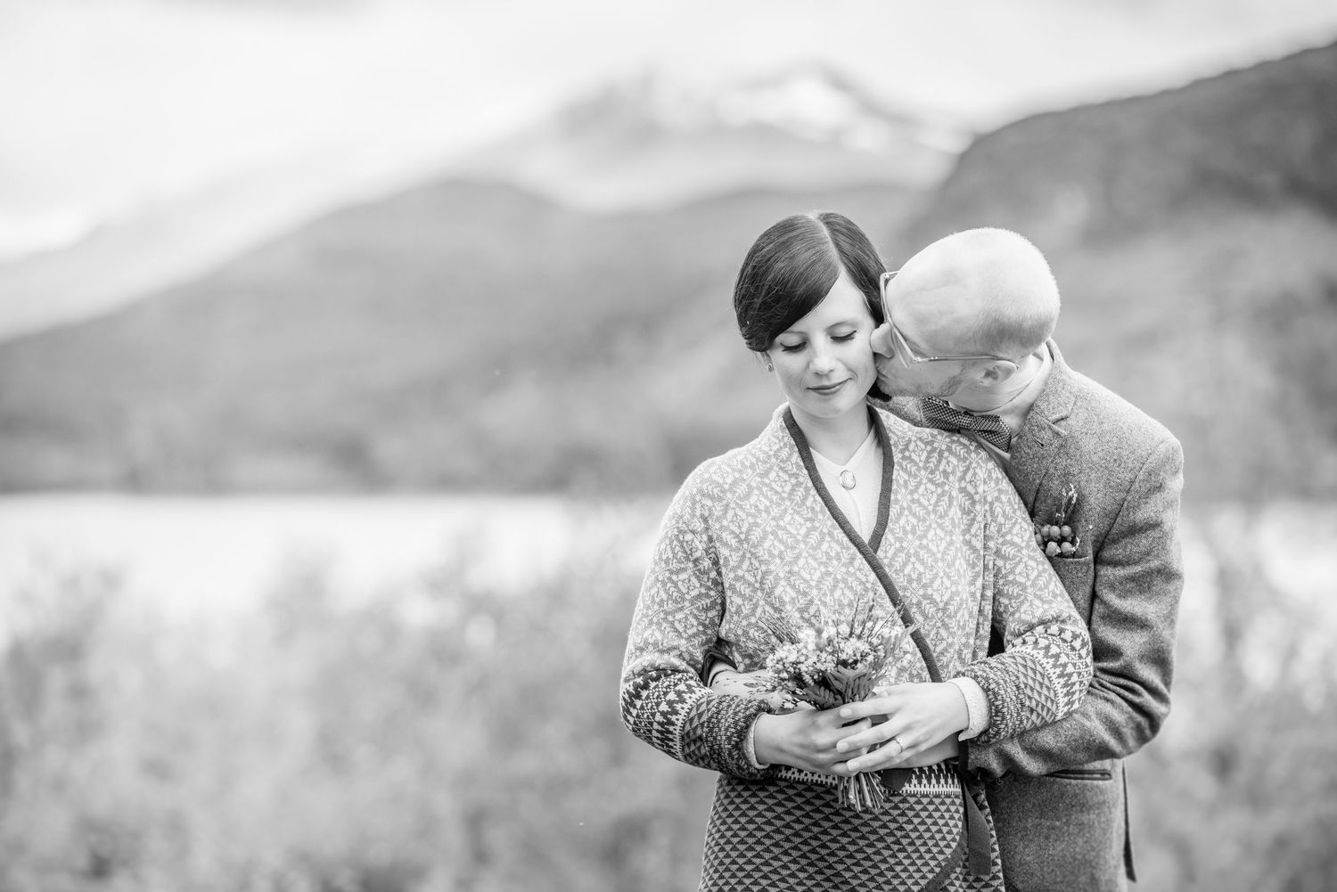 Intimate black and white portrait of a couple sharing a tender moment in nature.