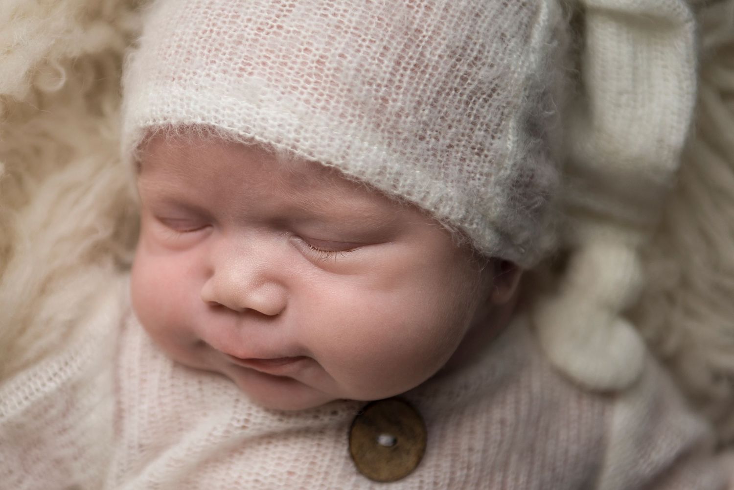 Artistic black and white portrait of a newborn wearing a cozy knit cap.