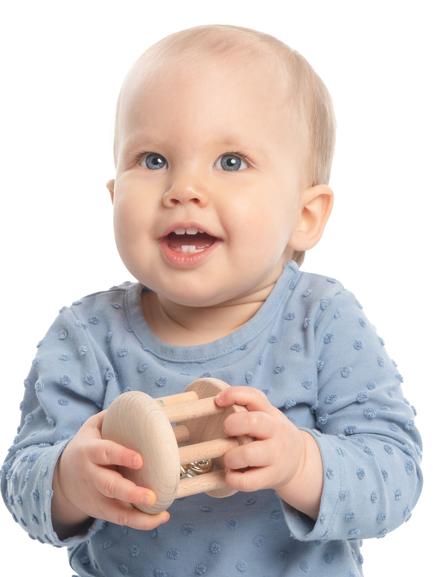 Baby in light blue polka dot outfit smiling while holding an egg.