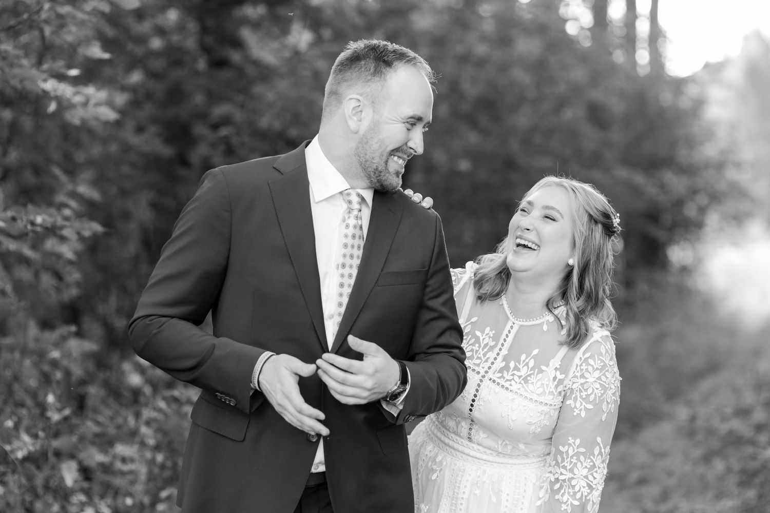 Black and white engagement photos capturing joyful laughter between the couple.